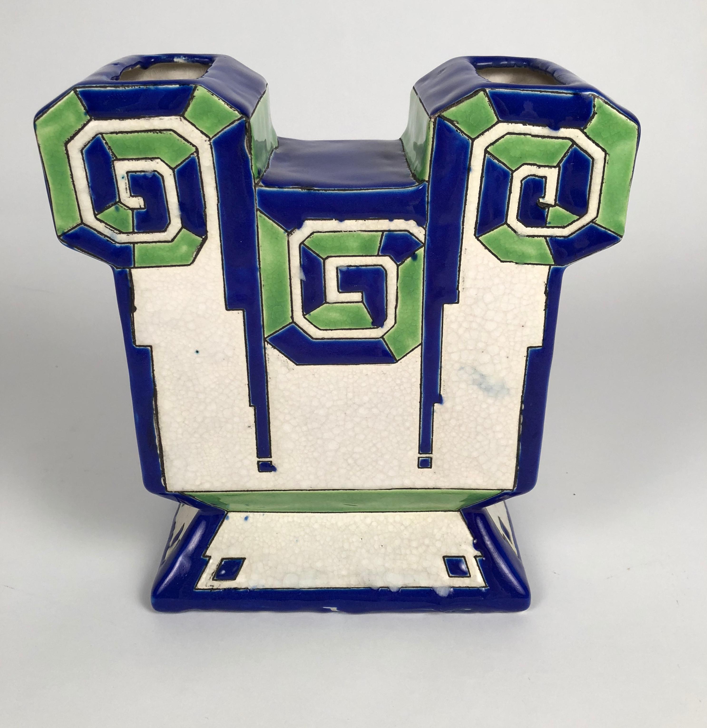 A Boch Frere Kermis Art Deco period blue and green ceramic vase, Belgian, circa 1930, of geometric form decorated with blue and green enamels, outlined in black on white, with a craquelure glazed field. Signed and numbered on the base.
This bold,