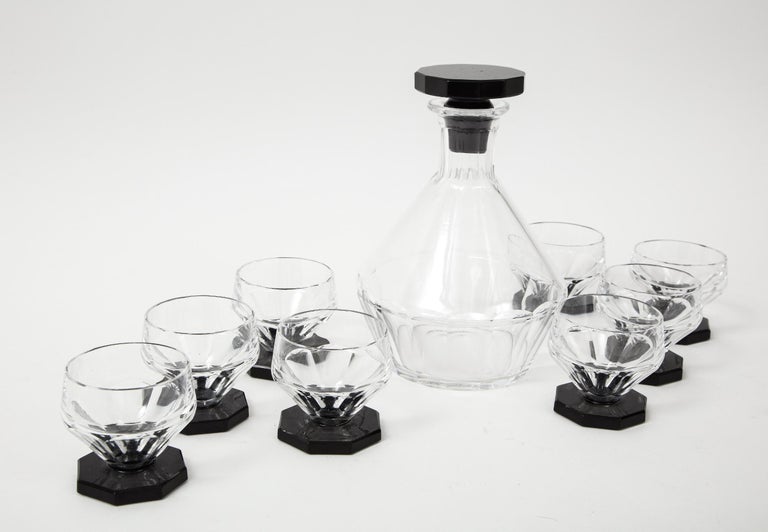A stylish period Art Deco crystal Decanter set with eight matching glasses with hexagonal black glass bases.