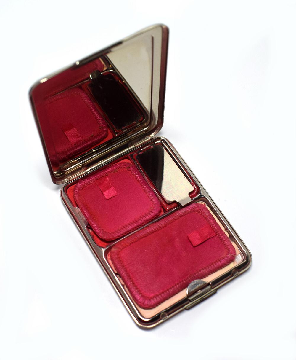 Early 1930s Art Deco Richard Hudnut Du Barry powder compact with remnants of the fine texture face powder in two-tones of bright red. Du Barry scent is still detectable despite the age of the powder. The back of the compact is engine turned with