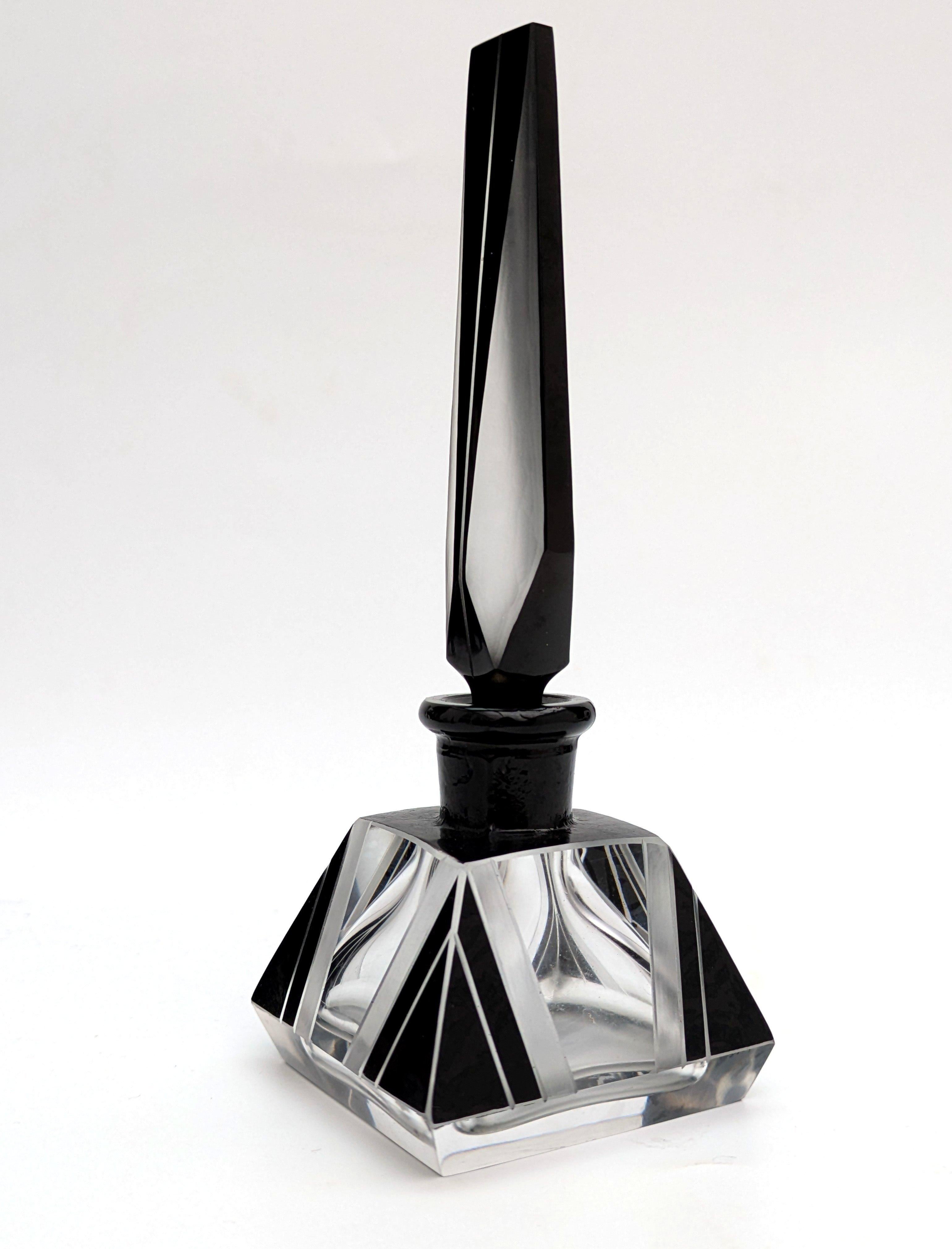 Bellissima bottiglia di profumo Art Deco ceca risalente agli anni '30. La bottiglia è in vetro trasparente con tappo originale e decorazioni in smalto nero con dettagli incisi all'acido. La bottiglia e il tappo hanno una favolosa forma geometrica,
