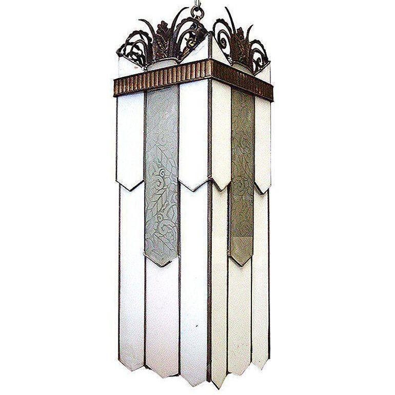 Questo lampadario geometrico in stile Art Déco è caratterizzato da pannelli in vetro acidato e in vetro al latte. Il piano è rifinito con motivi scultorei a scorrimento in bronzo.