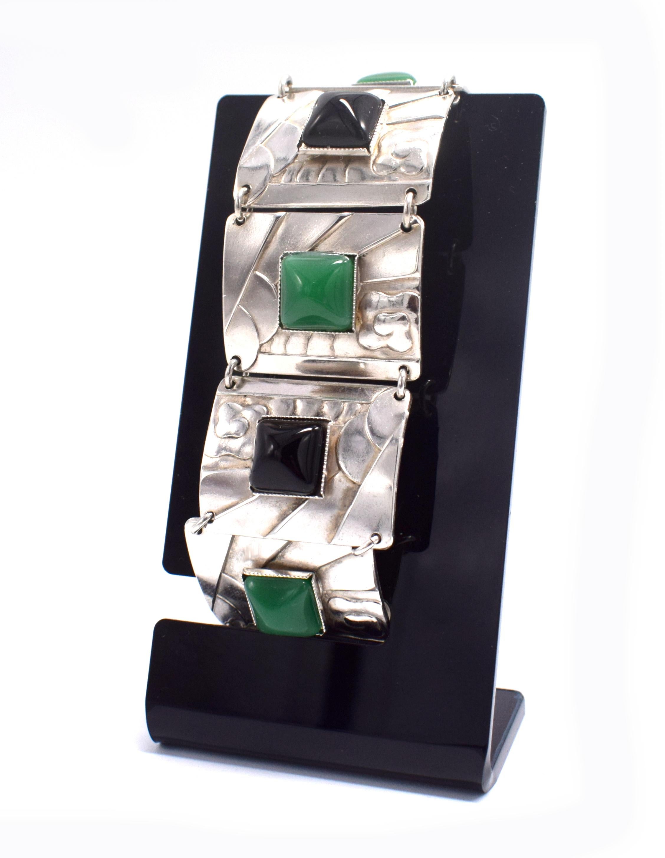 A real classic and very high quality ladies Art Deco Modernist bracelet, totally authentic and to the period, dating to the 1930's. Features an emerald green and black alternate stones which are mounted on silver plated linked panels which are