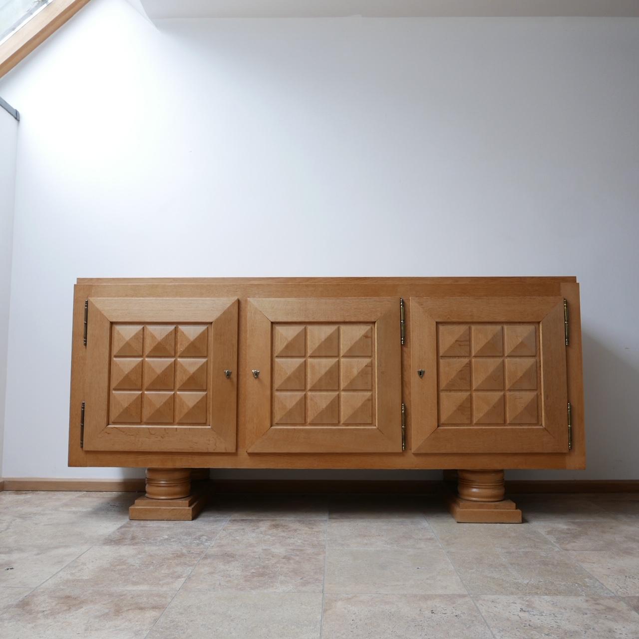 A large French credenza or sideboard.

France, circa 1940s in Art Deco style.

Three doors, with matching geometric shape design.

Raised over two stylish feet.

Dimensions: 101 H x 55 D x 208 W in cm.
 