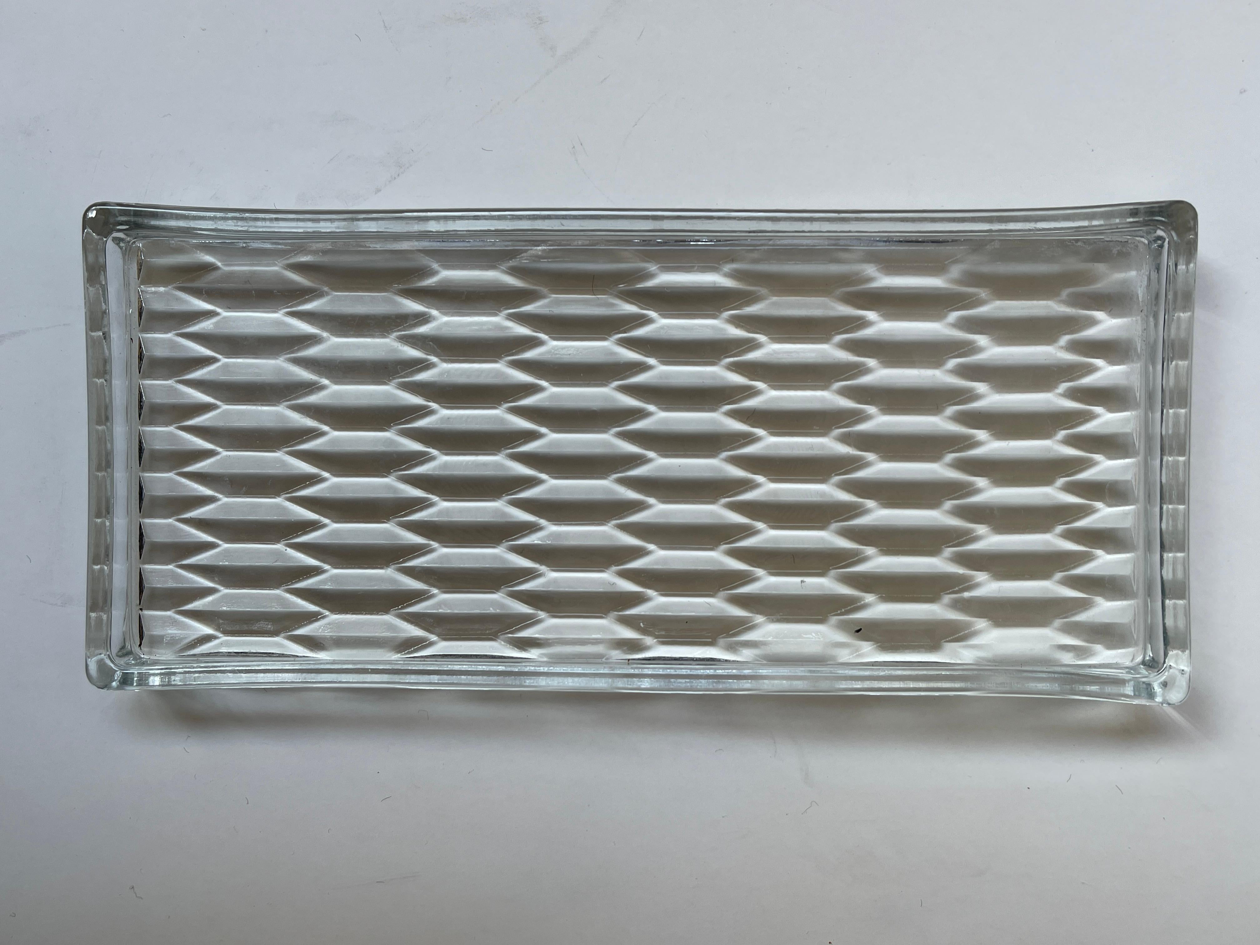 Plateau rectangulaire Art Déco en verre pressé à motifs géométriques, entouré d'un large rebord en verre. Utilisation idéale pour la vanité ou les articles de bar.
 Danemark, vers 1930-1940.