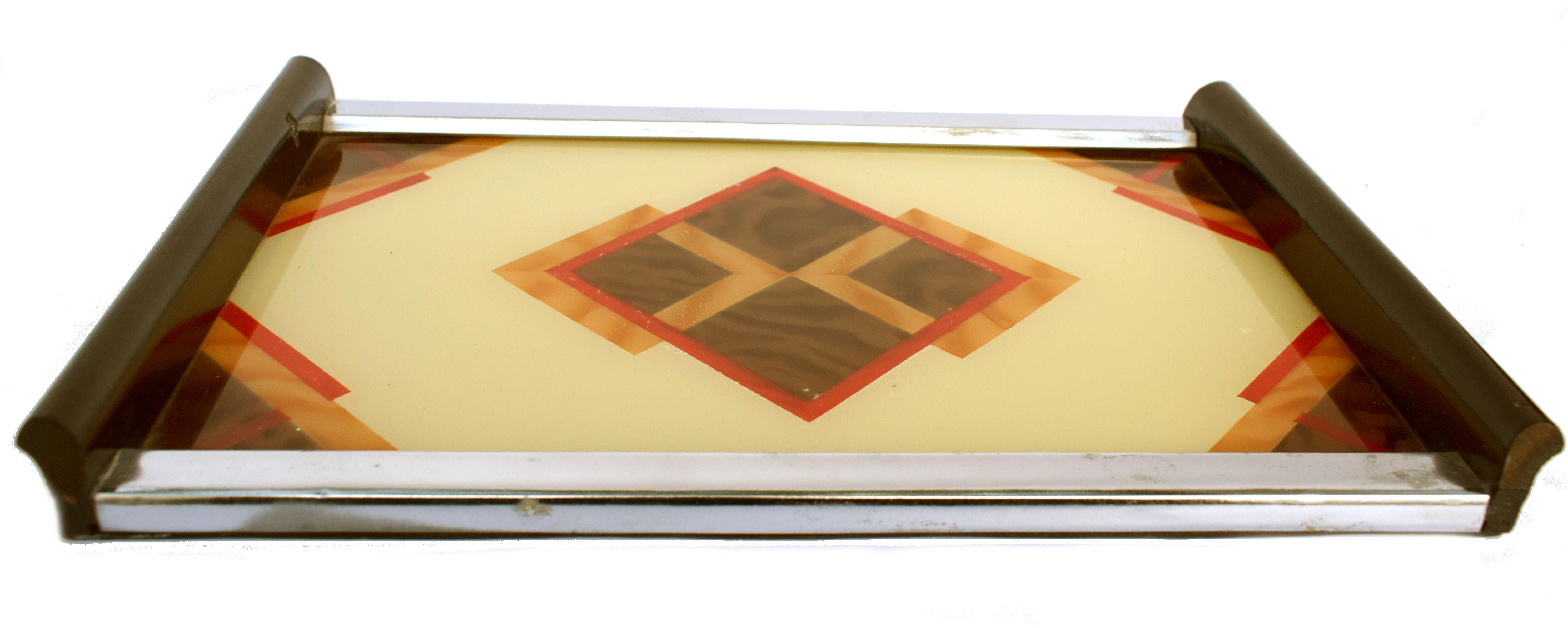 Original 1930s Art Deco tray made in Germany featuring a lovely reverse painted geometric design on glass. Wooden bar handles with chrome sides. Condition is very good. Very distinctive deco motif. Ideal for displaying your barware or serving