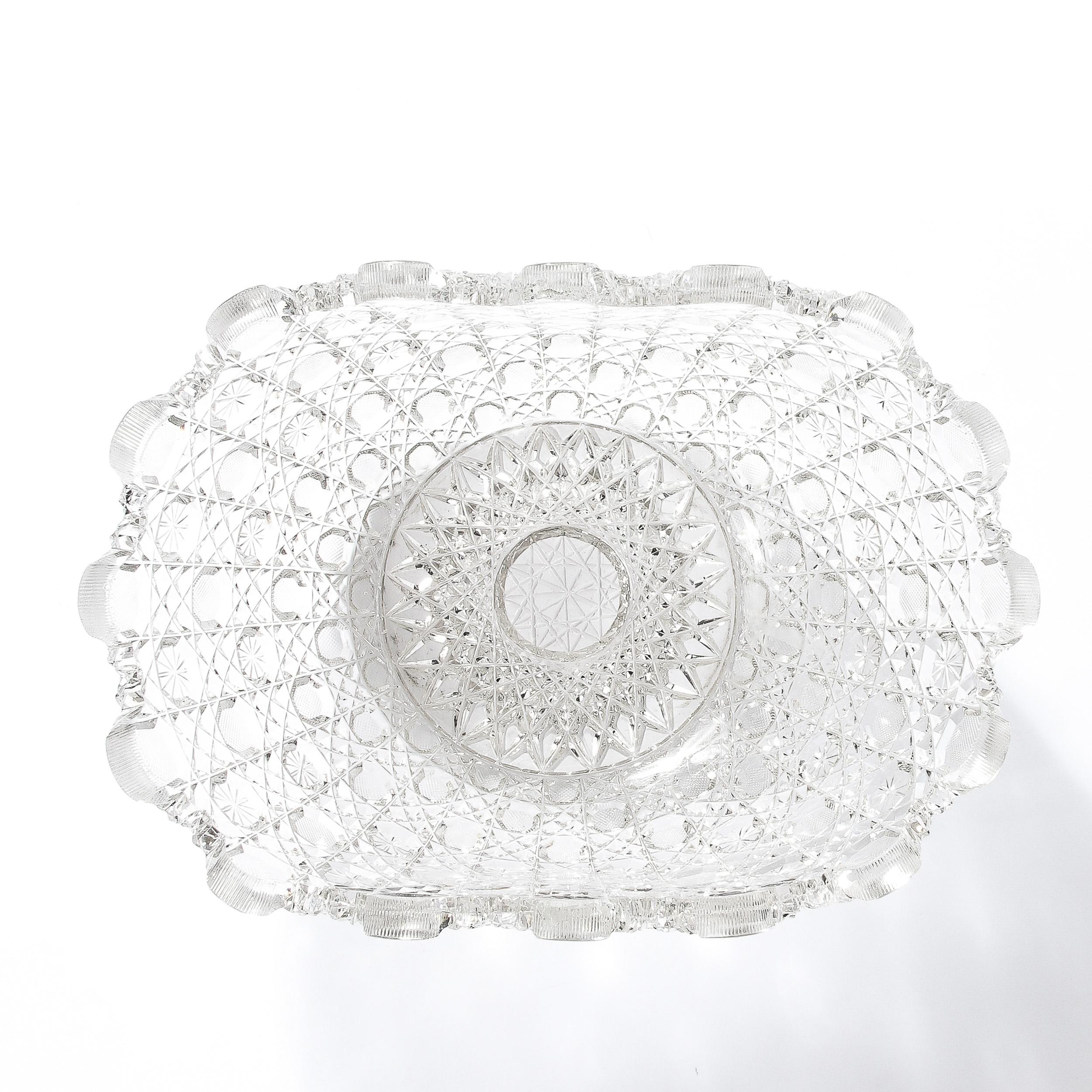 This refined Art Deco glass bowl was realized in the United States circa 1925. Realized in the celebrated Harvard pattern, this cut glass bowl offers an abundance of starburst patterns and geometries; as well as circular and jewel-like, prismatic