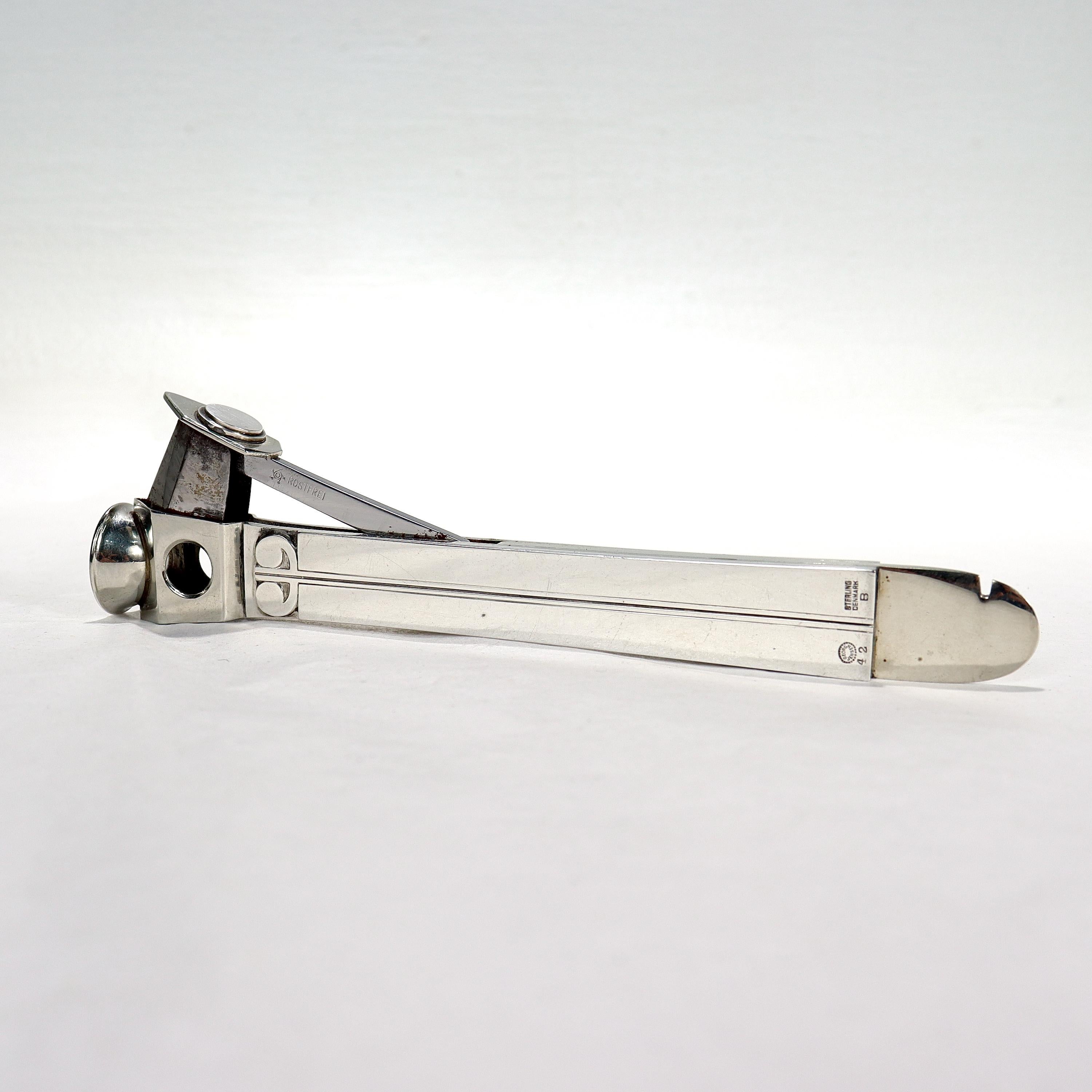 A fine Art Deco sterling silver cigar cutter.

By Georg Jensen.

Model no. 42B

With sterling silver panels mounted on a stainless steel base.

Simply wonderful Art Deco design!

Date:
20th Century

Overall Condition:
It is in overall good,