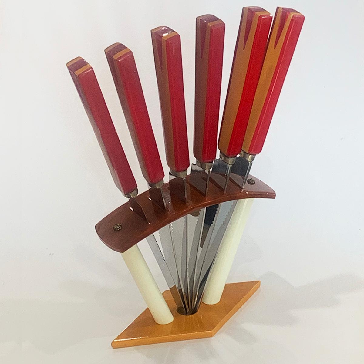 Art Deco German bakelite fruit knife set, of 6, with fantastic translucent red bakelite handles spliced with orange, on the original geometric bakelite stand in white and brown Bakelite. All in excellent condition and the stainless steel blades are
