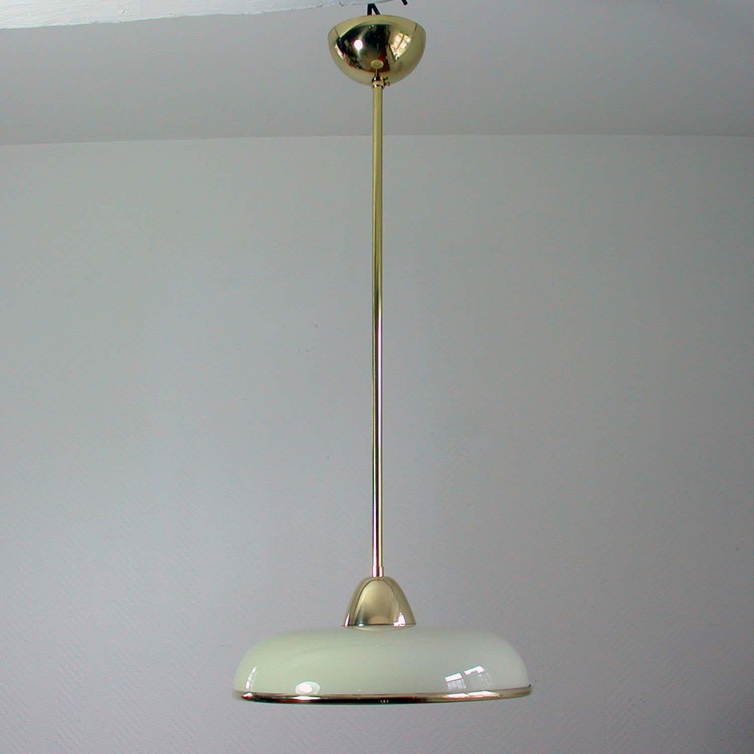 This elegant German pendant was designed and made in Germany in the 1930s. The lamp is made of brass and has got a cream colored Opaline glass shade in typical Bauhaus design with a brass rim. Good vintage condition with one E27 socket.

The lamp