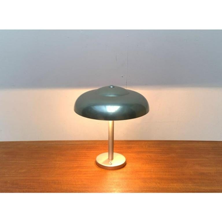 Elegant table lamp from wmf from the 1930s.

a functional design. The simple umbrella shape is broken up by an additional cathedral on the top. A very subtle, decorative element on this very simple lamp. The umbrella is connected to the shaft via a