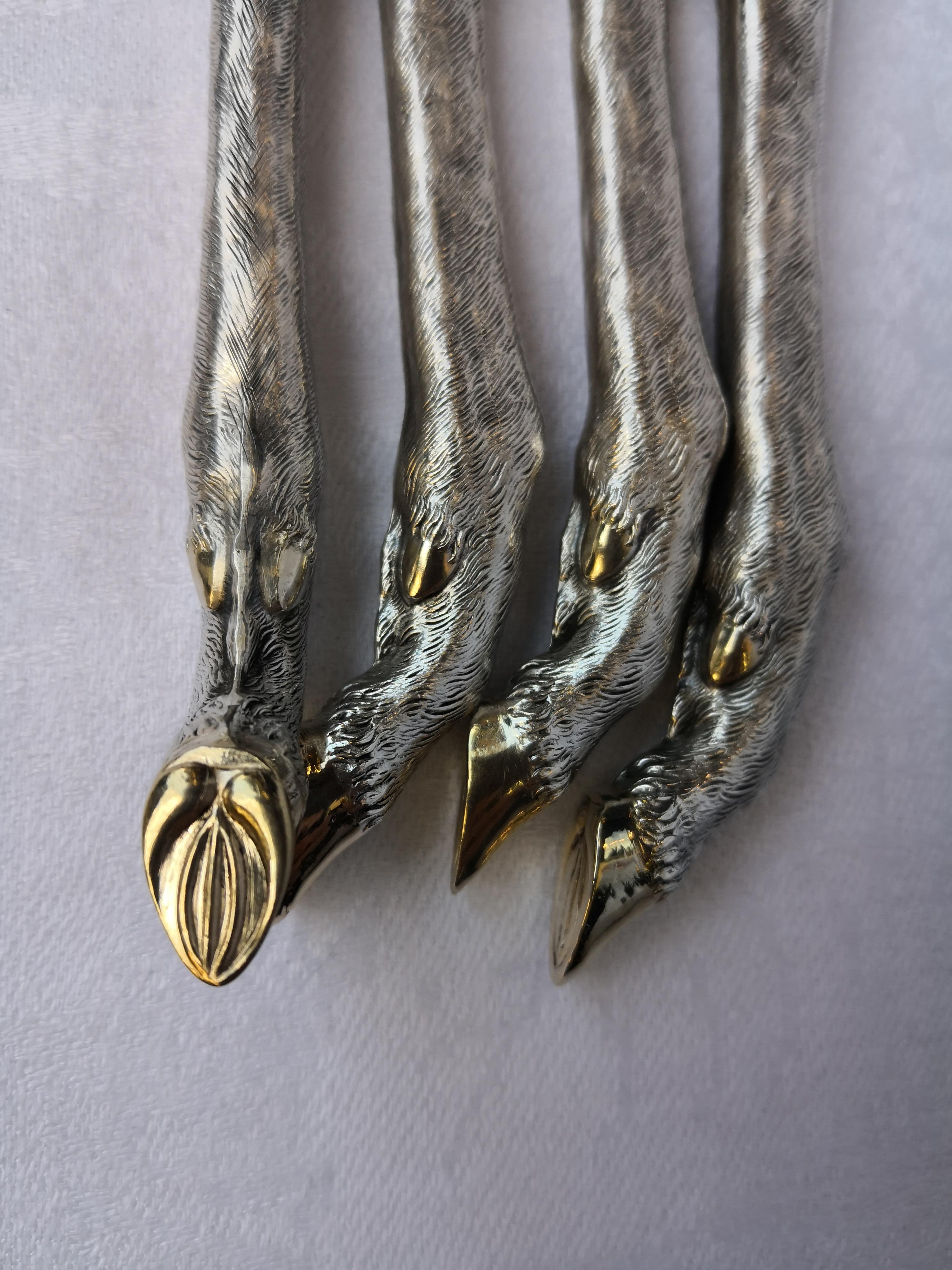 Impressive and fine handmade set of four serving cutlery in 800 silver. The handles are formed as exceptional detailed stag hooves in 800 silver on the end of each piece. The upon parts are stamped steel and gold gilt. Perfect table decoration for