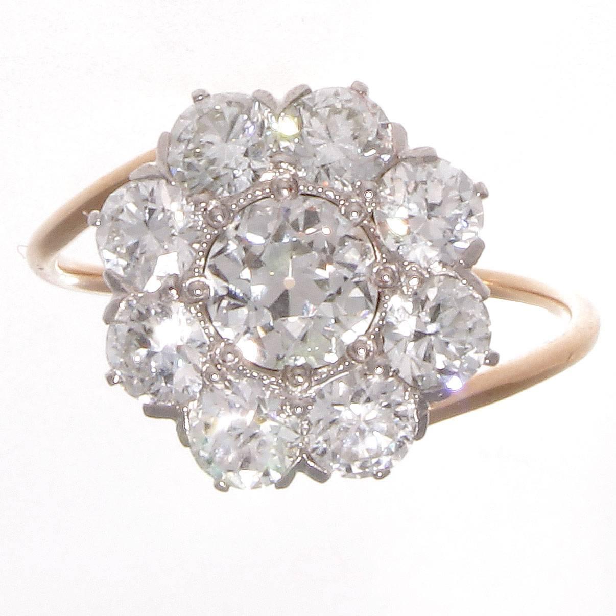 A glowing flower motif constructed of a cluster of diamonds from the ever desirable art deco time era. Featuring a GIA certified 0.63 carat old european cut dimaond that is graded H color, VS1 clarity. Surrounded by a halo of 8 old cut diamonds