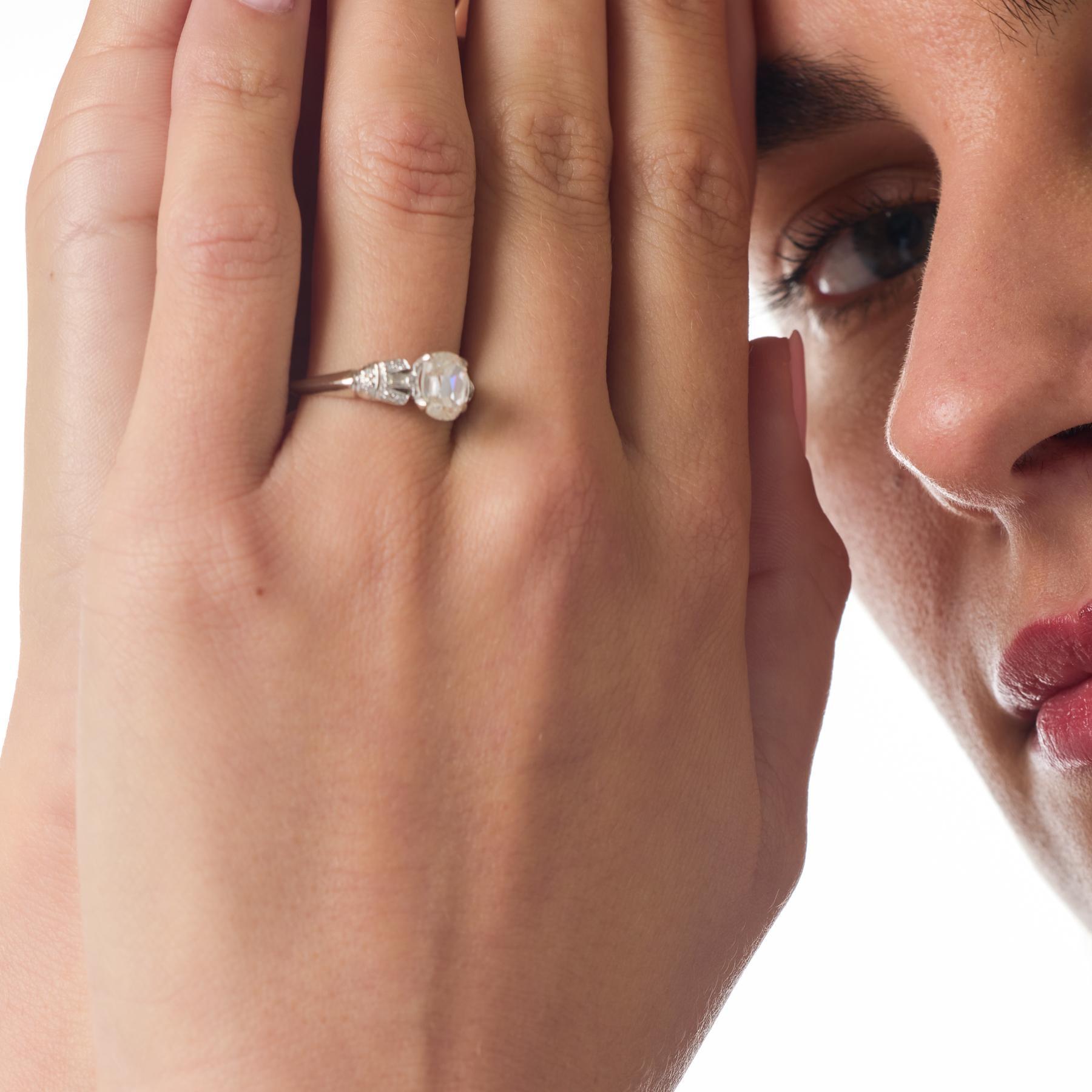 Questo anello di fidanzamento Art Déco presenta un raffinato diamante brillante a cuscino incorniciato dalla geometria pulita e dalla simmetria equilibrata che definiscono l'epoca. Eleganti diamanti a baguette e delicati diamanti a taglio singolo