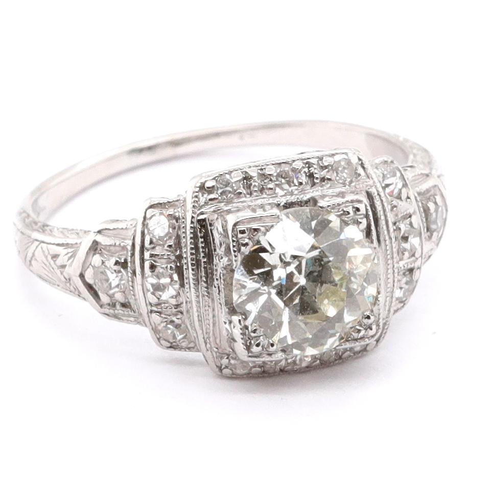 This ring is truly an Art Deco masterpiece, featuring symmetry, fine detail, and a display of elegance synonymous with the era. What was a trend in 1920's now is a reminder of that wonderful time. The center stone is GIA certified as 1.03 carat Old