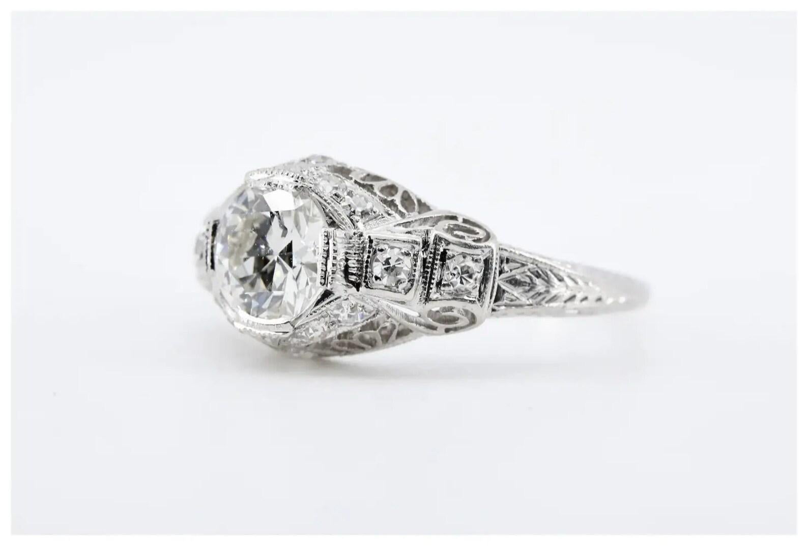 
An Art Deco period handmade filigree engagement ring crafted in lustrous platinum.

Centered by a GIA certified 0.85 Carat round Circular Brilliant cut diamond of I color, and VS2 clarity.

Accented throughout by 14 pave set diamonds of 0.21ctw