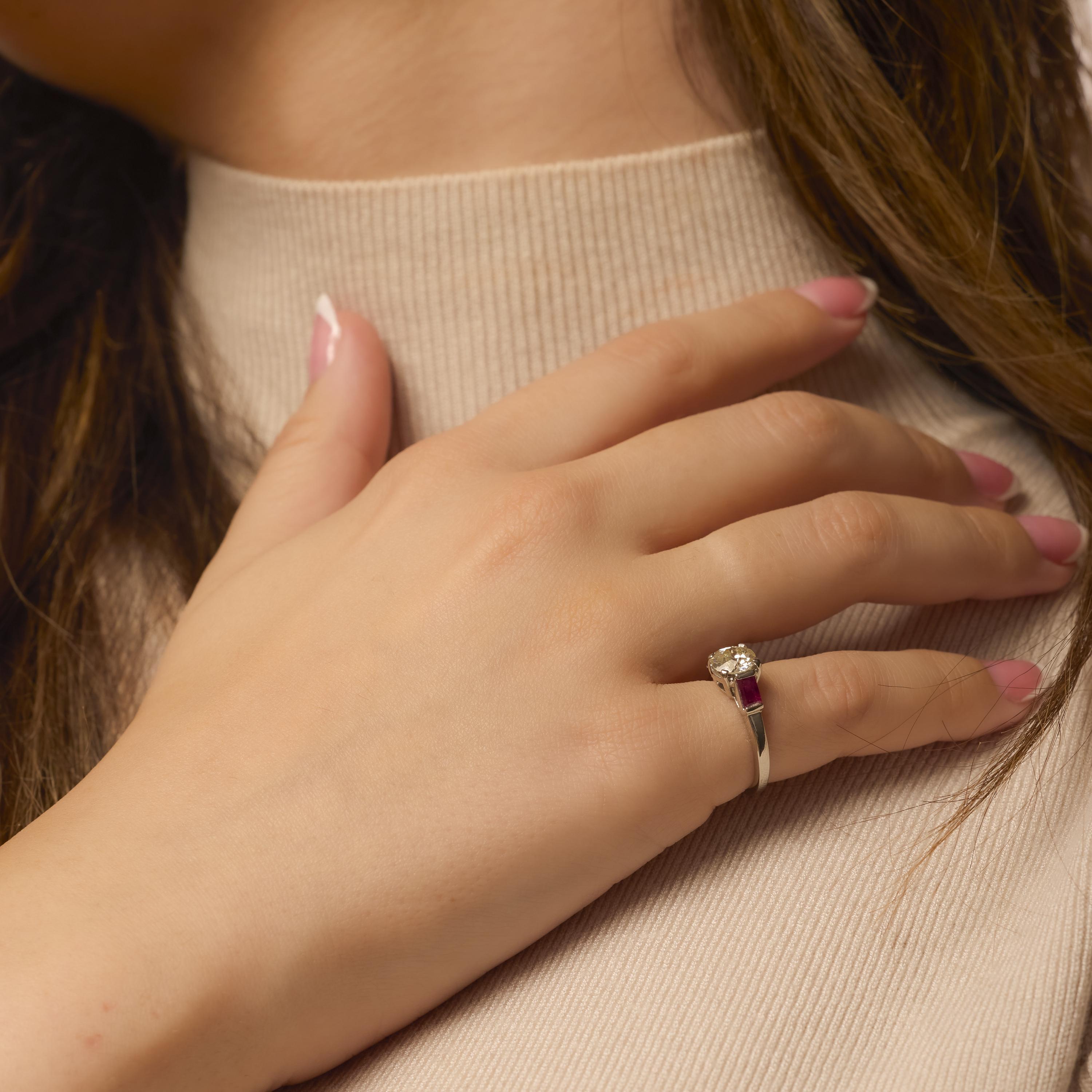 This Art Deco platinum ring features a bold 1.08 carat old European cut diamond flanked by vivid baguette rubies, showcasing elegant geometry and rich vintage charm.