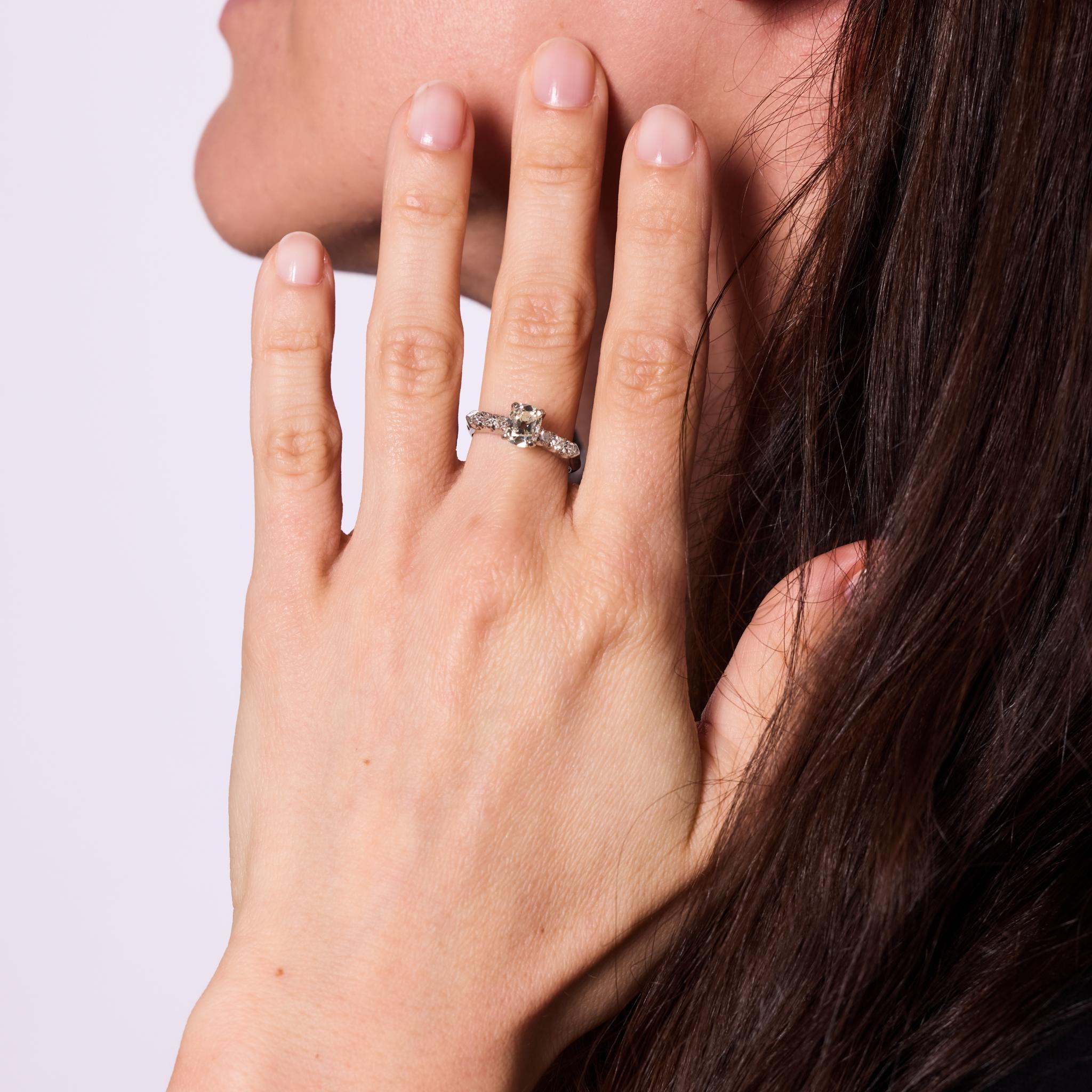 Crafted in the 1930s, this Art Deco engagement ring highlights a GIA-certified 1.10-carat old mine cut diamond, graded L color and outstanding VVS1 clarity. Framed by six single cut diamonds totaling approximately .20 carats, H color and VS clarity,