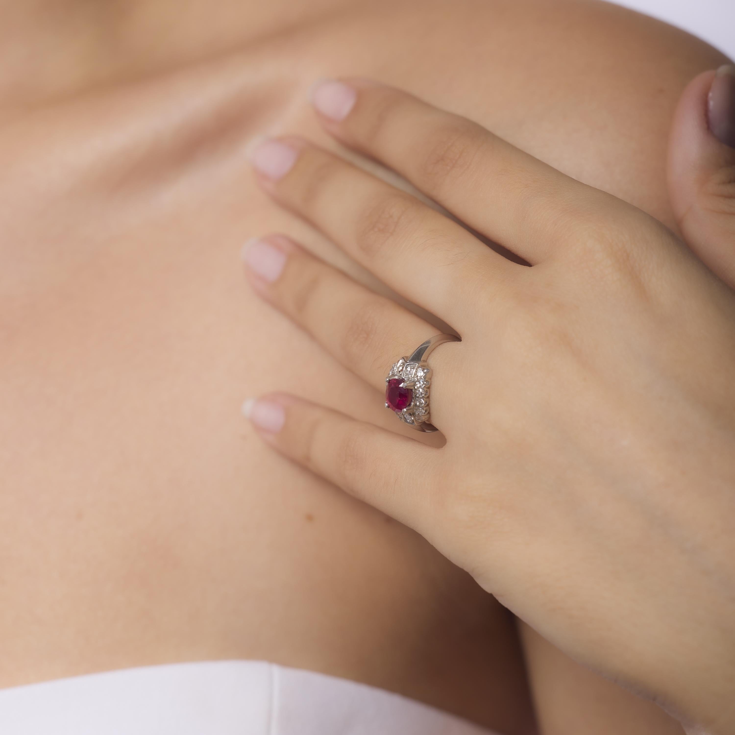 This Art Deco platinum ring showcases a vivid 1.15 carat GIA-certified heated ruby from Thailand, framed by sixteen sparkling single cut diamonds in a geometric setting. Crafted in the 1930s, its bold lines and rich color epitomize the elegance and