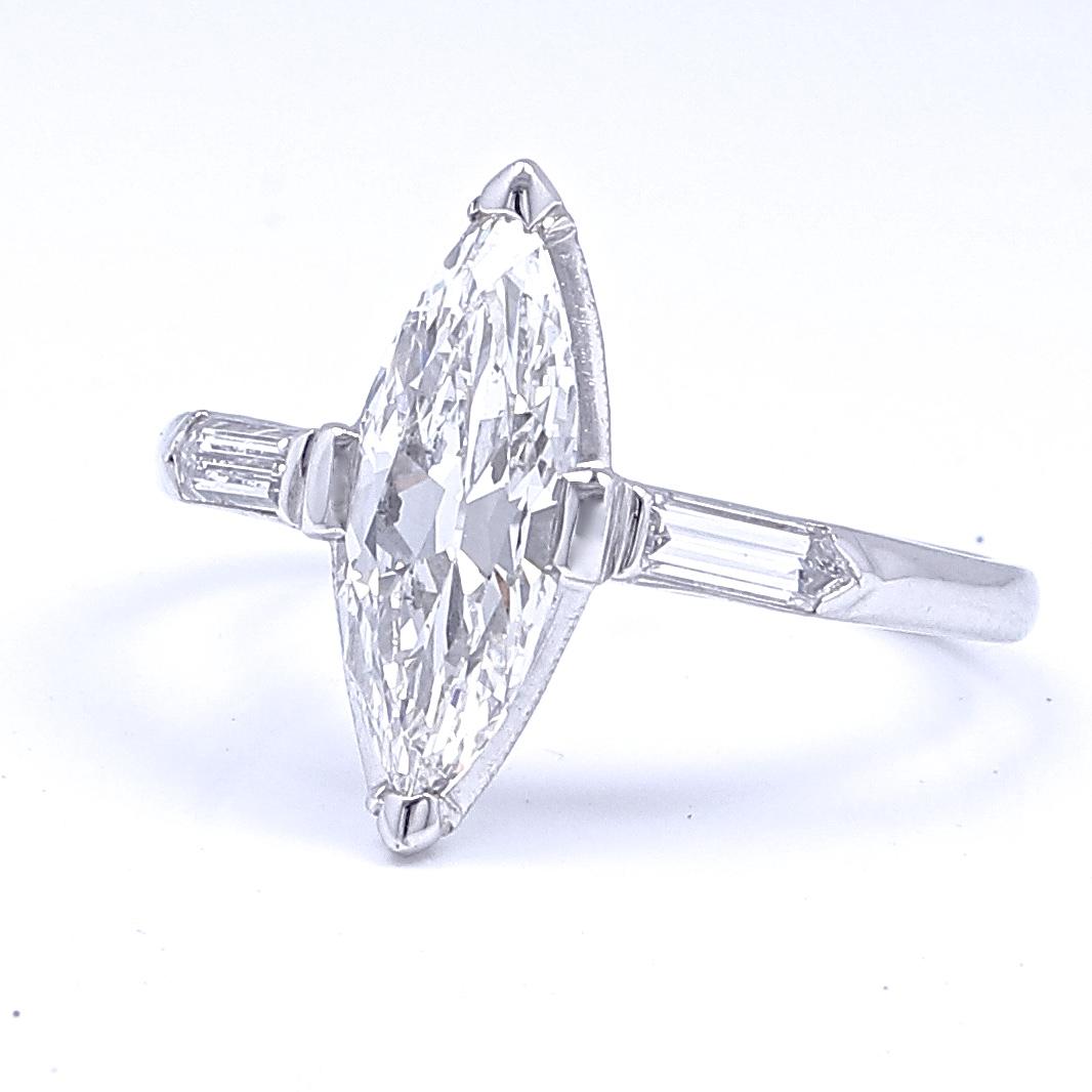 This is a sleek elegant Art Deco ring comfortable wherever good cocktails are served. The superb marquise cut diamond is GIA  certified as weighing 1.15 carats,  H color VS2 clarity.  Accented by 2 bullet cut diamonds weighing approximately  0.30