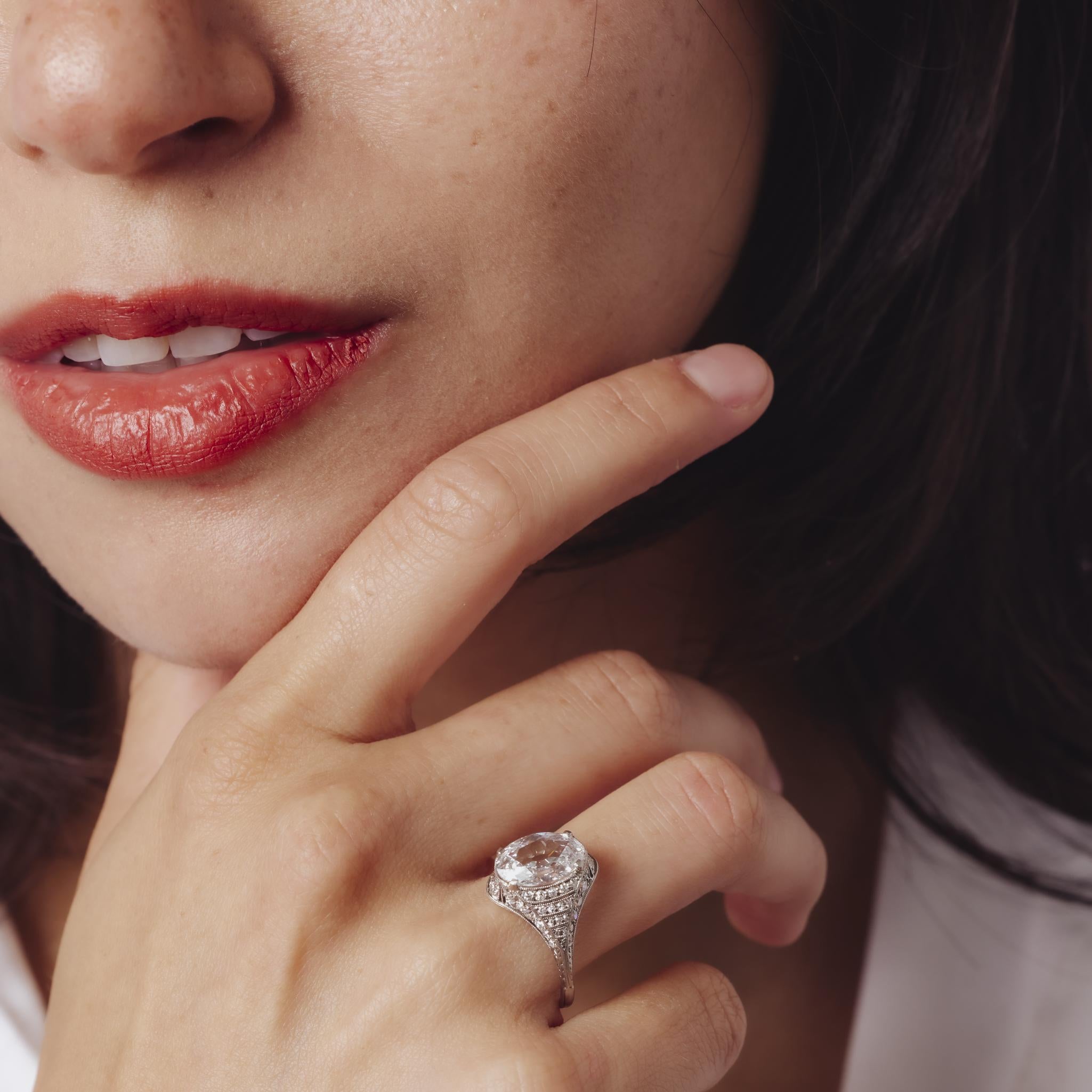 Cette exquise bague Art déco en platine est centrée sur un diamant ovale de 1,52 carat de couleur F certifié par le GIA, entouré de 58 diamants de taille européenne ancienne qui capturent la géométrie raffinée et le glamour intemporel des années