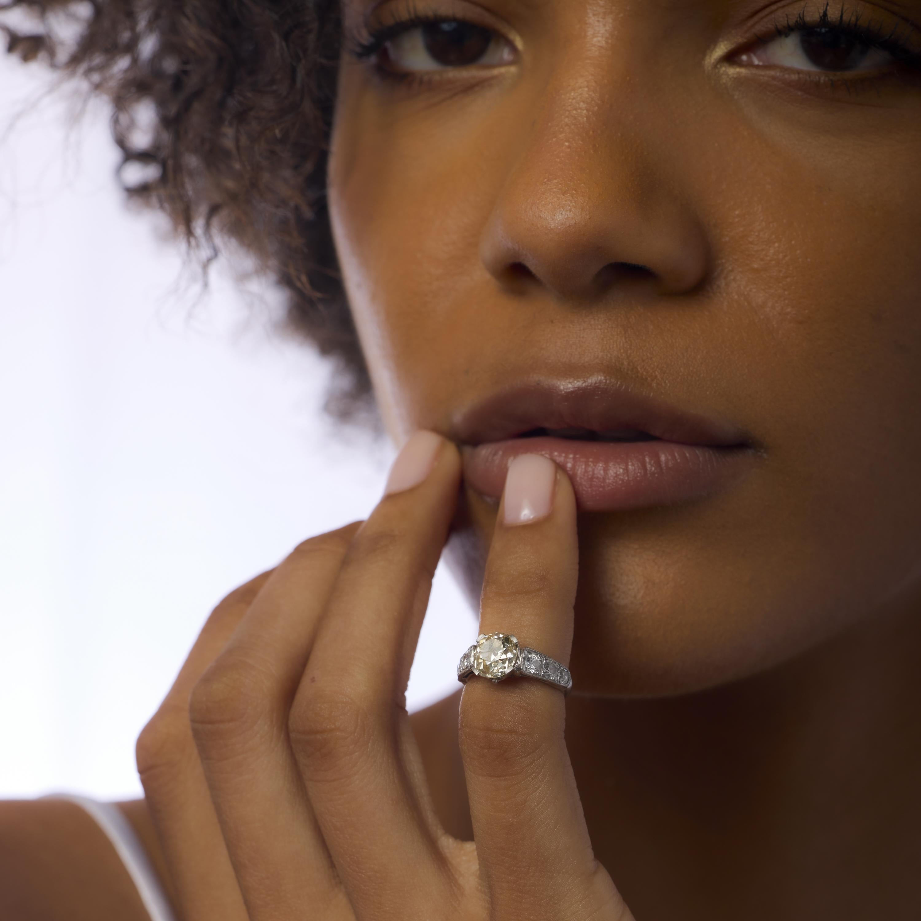 Este anillo Art Déco de los años 30 exhibe un distintivo diamante tallado en mina antigua de 1,70 quilates con un tono amarillo marrón claro fantasía certificado por el GIA y claridad I1, que irradia suave calidez y carácter vintage. Enmarcado por