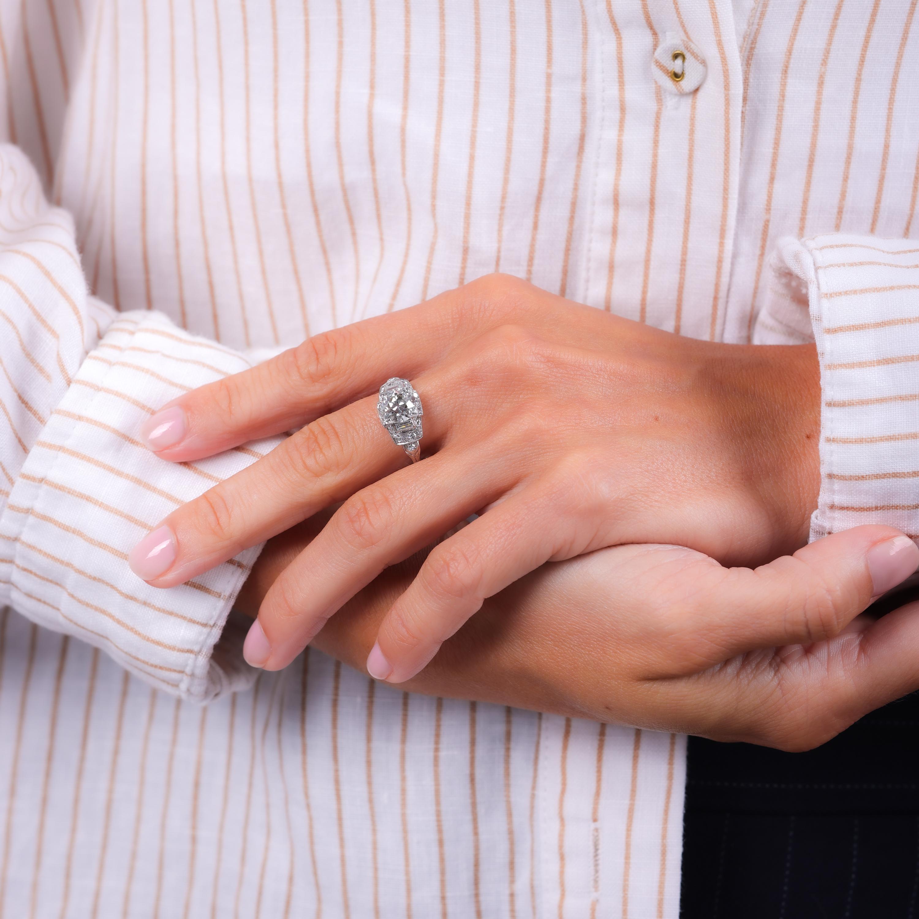 Mittelstein: Diamant im alten europäischen Schliff
Zertifikat: GIA #6234383709
Gewicht: 2,05 Karat
Farbe: L
Klarheit: SI1
Akzentstein: 2 Diamanten im Baguetteschliff und 24 Diamanten im Einzelschliff
Gewicht: Ungefähr 1 Karat
Farbe: H
Klarheit: