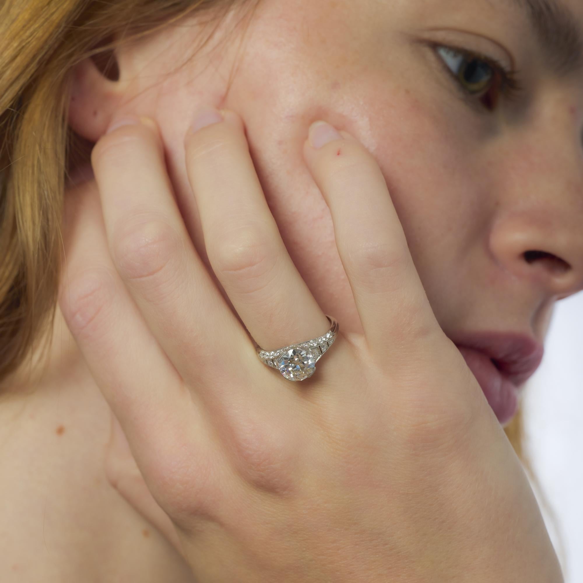 Questo anello Art Déco in platino presenta un diamante vecchio taglio europeo da 2,07 carati, incorniciato da vibranti diamanti vintage in un design raffinato e grazioso.