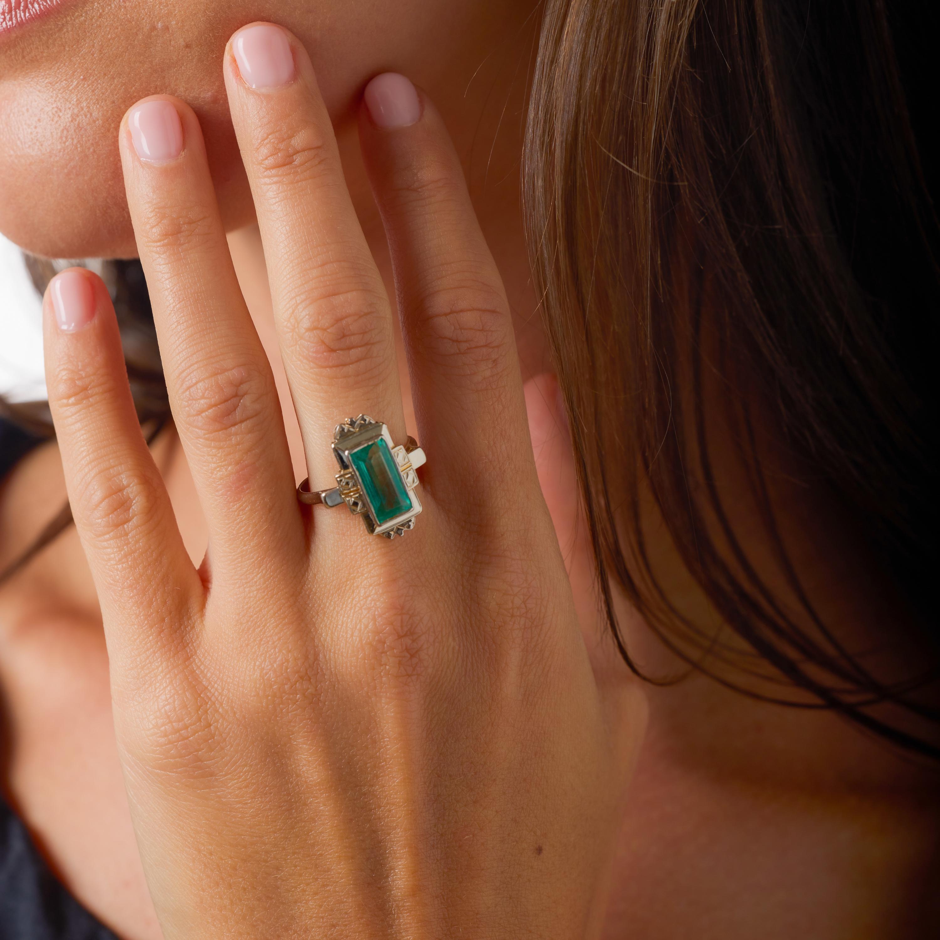 Cette remarquable bague Art déco est ornée d'une captivante émeraude colombienne de 2,10 carats, certifiée par le GIA et célèbre pour sa riche teinte verte et sa taille baguette raffinée, une silhouette élégante prisée par les maîtres joailliers des