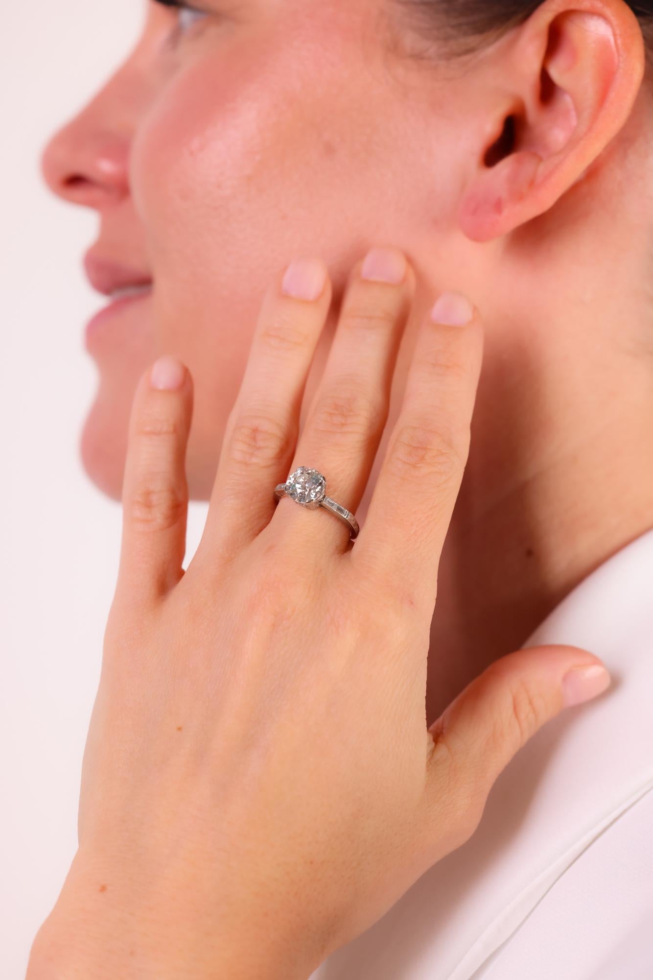 Cette bague de fiançailles Art déco en platine est ornée d'un superbe diamant circulaire brillant de 2,12 carats certifié par la GIA, rehaussé d'élégants accents en diamant baguette.

Certificat : GIA #5221930578
Pierre centrale : Diamant circulaire