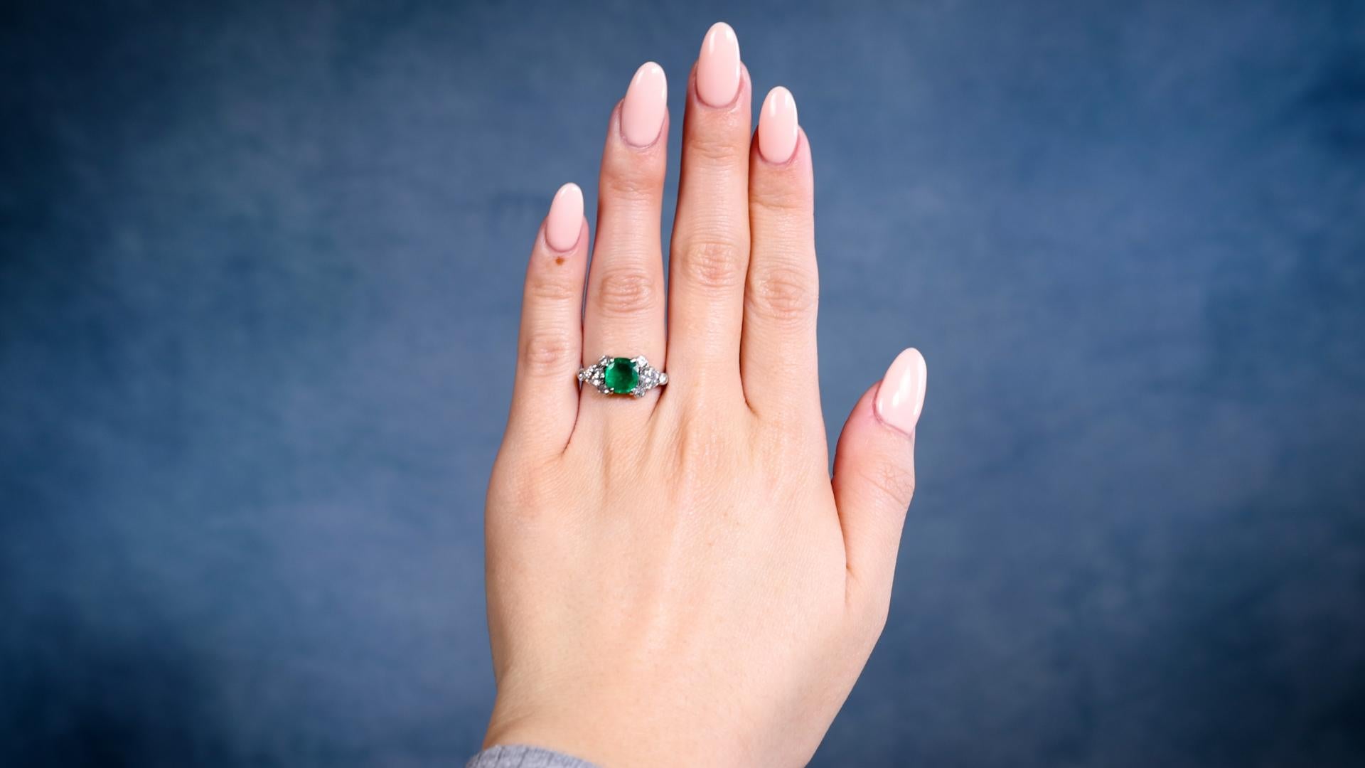 One Art Deco GIA 2.42 Carat Brazilian Emerald and Diamond Silver Ring. Featuring one GIA cushion mixed cut emerald weighing 2.42 carats, accompanied by GIA #2235177985 stating the emerald is of Brazilian origin. Accented by eight single and old