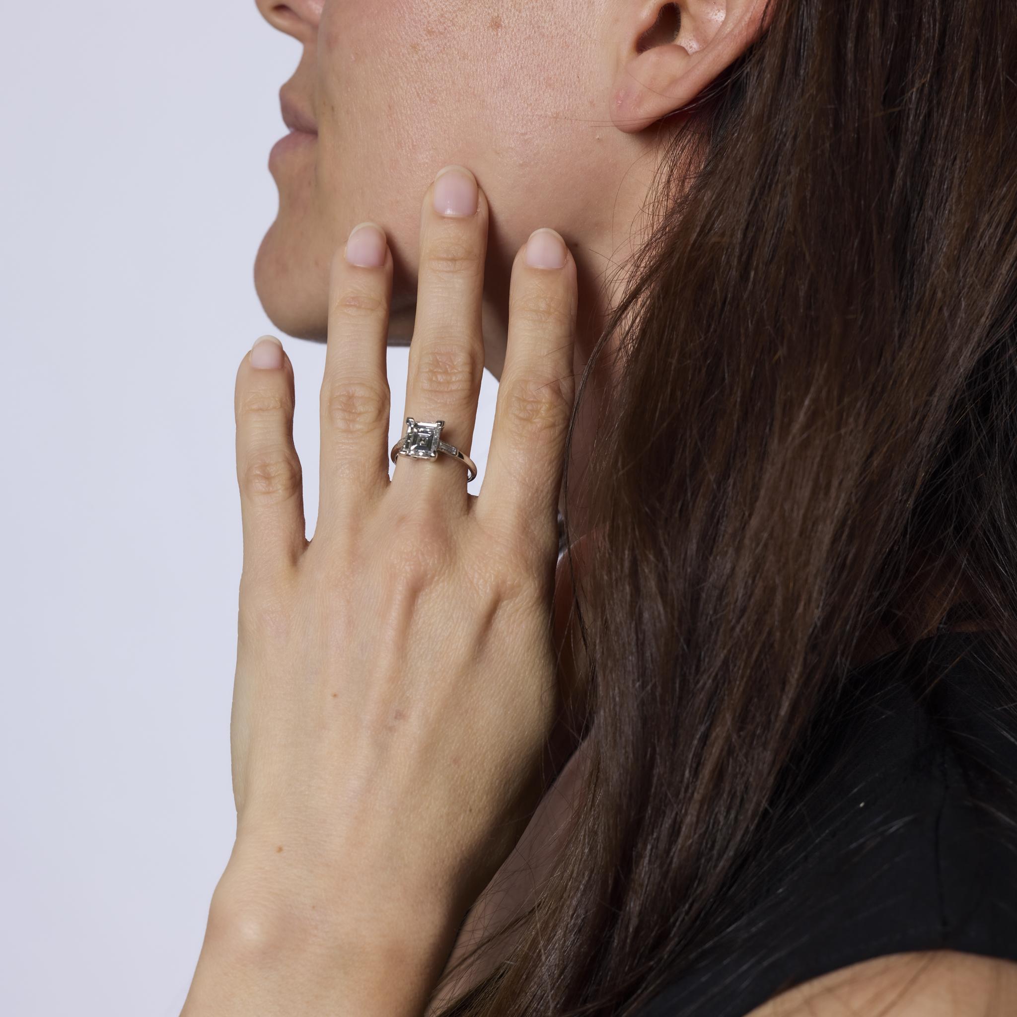 This exquisite Art Deco ring showcases a GIA-certified 2.56 carat D color carré cut diamond, flanked by sleek baguette cut diamonds. Crafted in platinum, it radiates the sharp elegance and timeless sophistication of the 1930s.