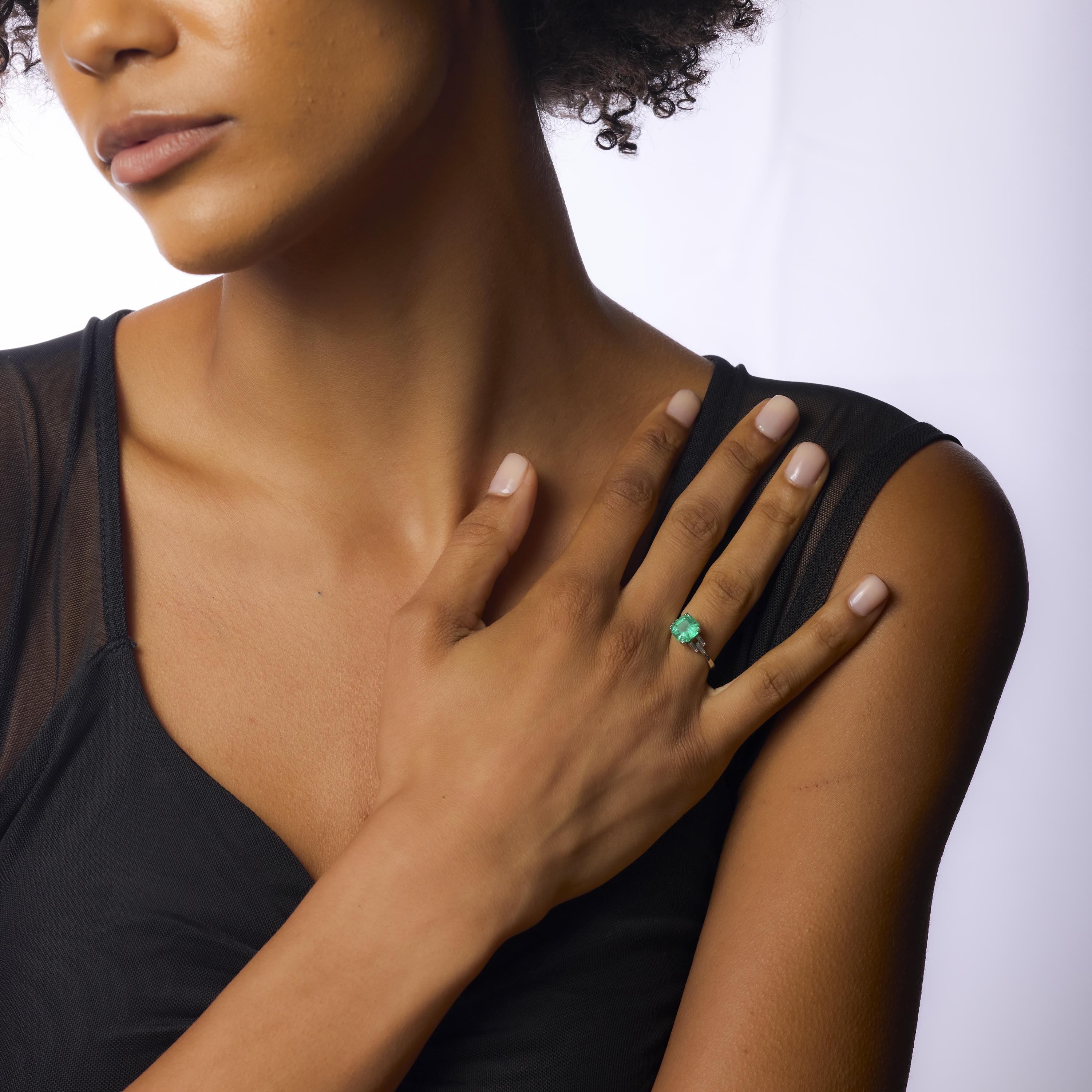 Este elegante anillo Art Déco de los años 30 exhibe una esmeralda colombiana de 2,80 quilates, de talla octogonal y color ricamente saturado, certificada por el GIA y tratada F2. La esmeralda está flanqueada por seis elegantes diamantes talla