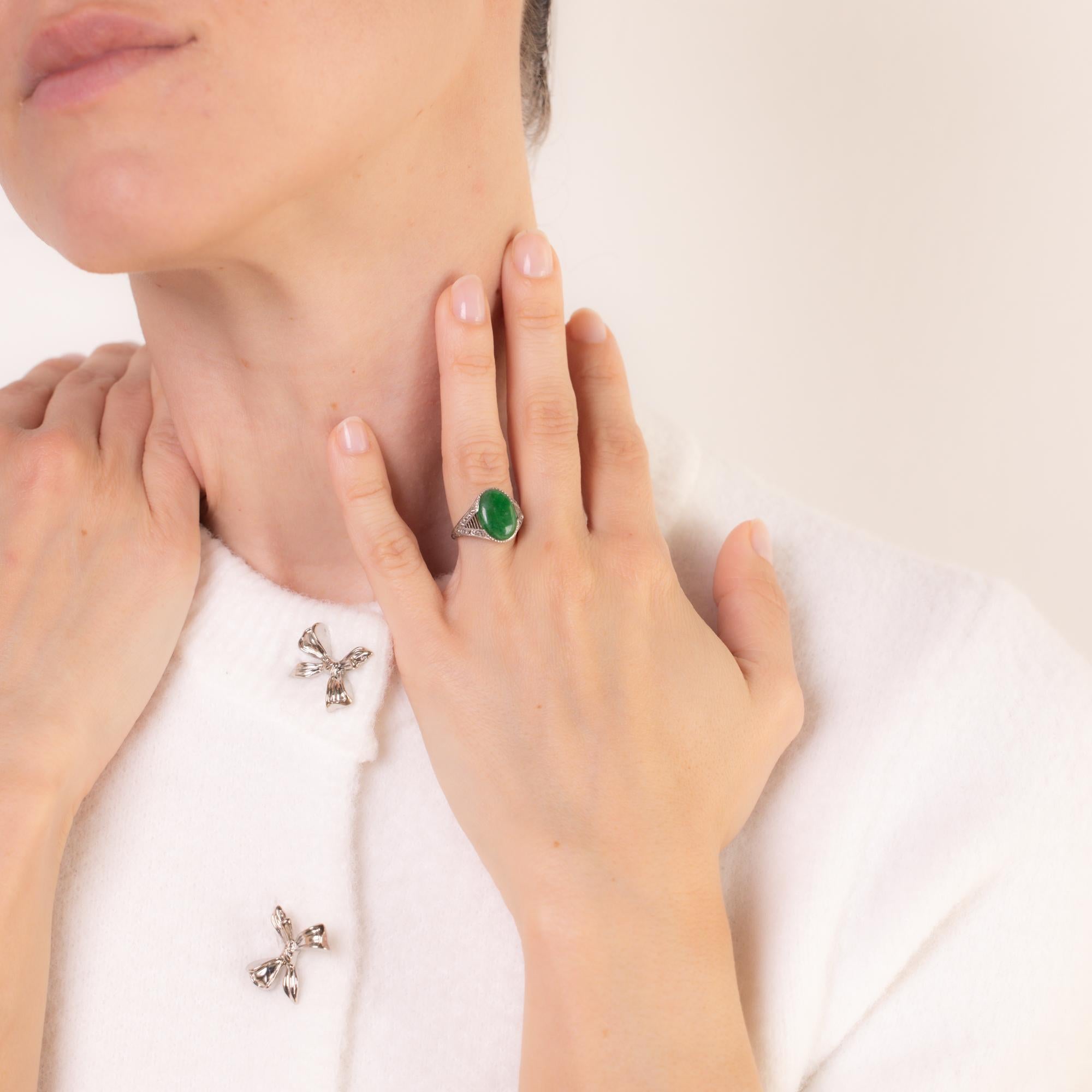 Cette bague Art déco en platine présente un jade ovale d'environ 3 carats, certifié par le GIA, taillé en cabochon, sans traitement, accentué par 18 diamants de taille française totalisant environ 0,50 carats, couleur E-F, pureté VS. Circa