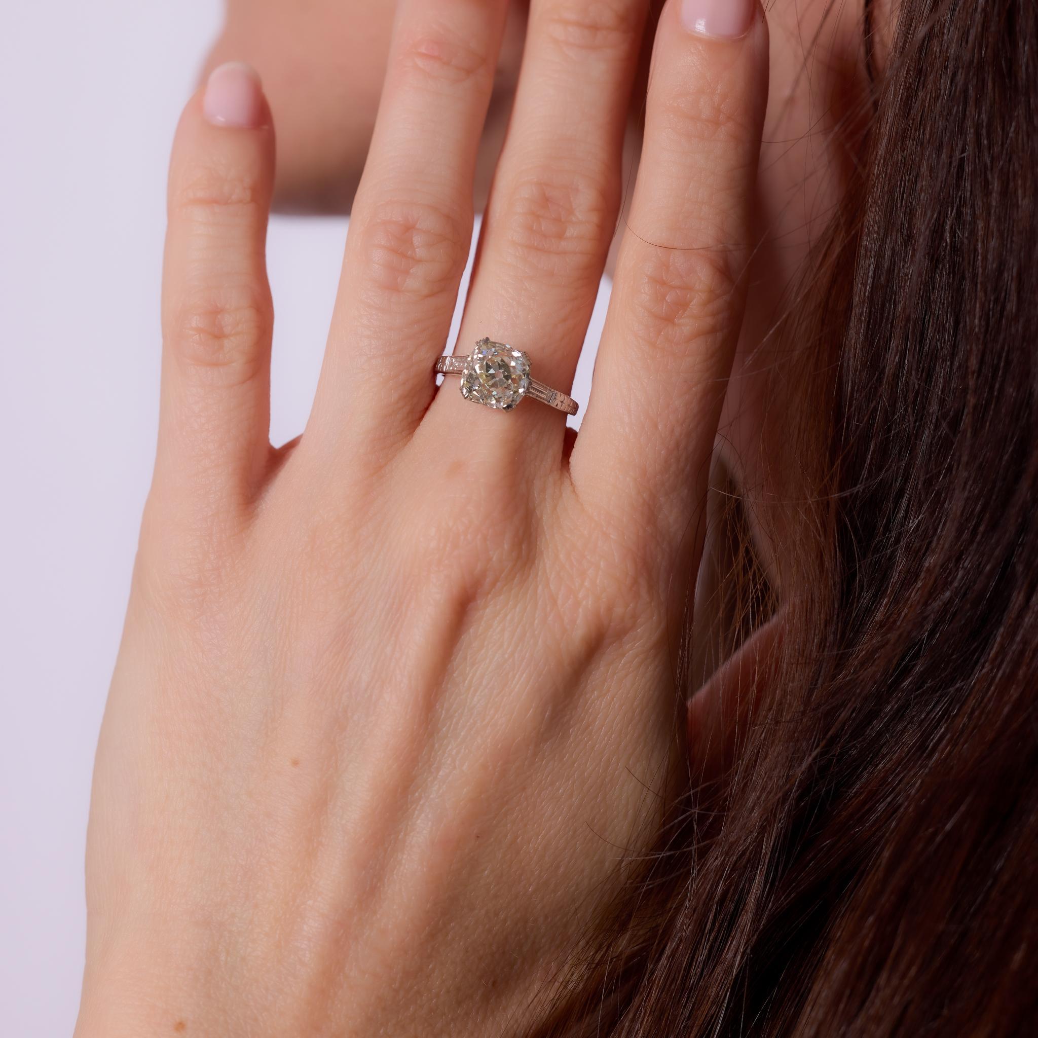 Crafted in the 1930s, this Art Deco engagement ring centers a GIA-certified 3.10-carat old mine cut diamond, graded N color and SI1 clarity. The diamond’s antique faceting and soft, romantic glow are complemented by two baguette cut diamonds