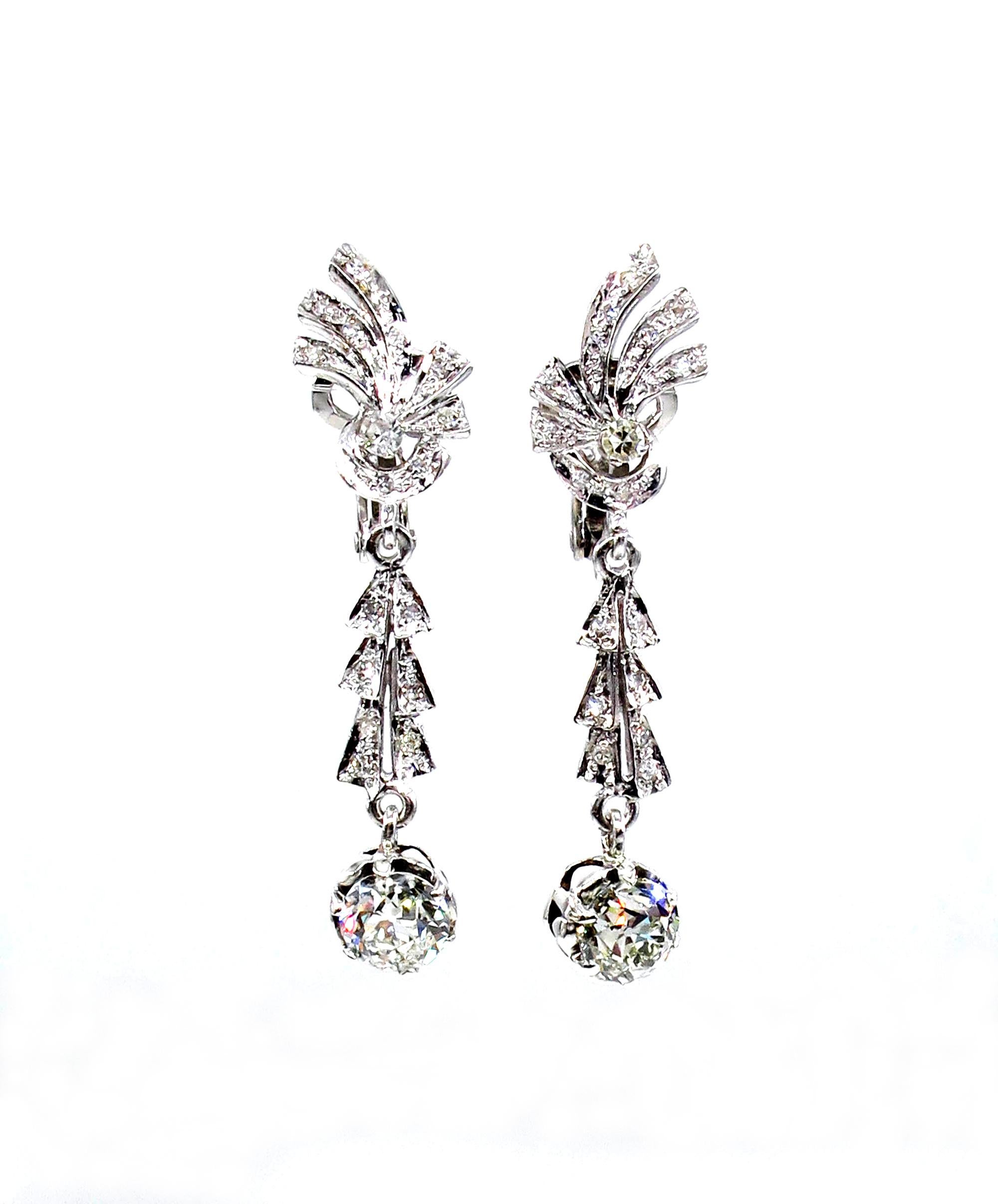 A sleek and sexy pair of ART DECO Diamond Drop Earrings with bright and sparkling Old European diamonds in Buttercup settings suspend from glittering fanciful diamond flares in these almost 1 3/4 inches long and extraordinarily lovely and lustrous