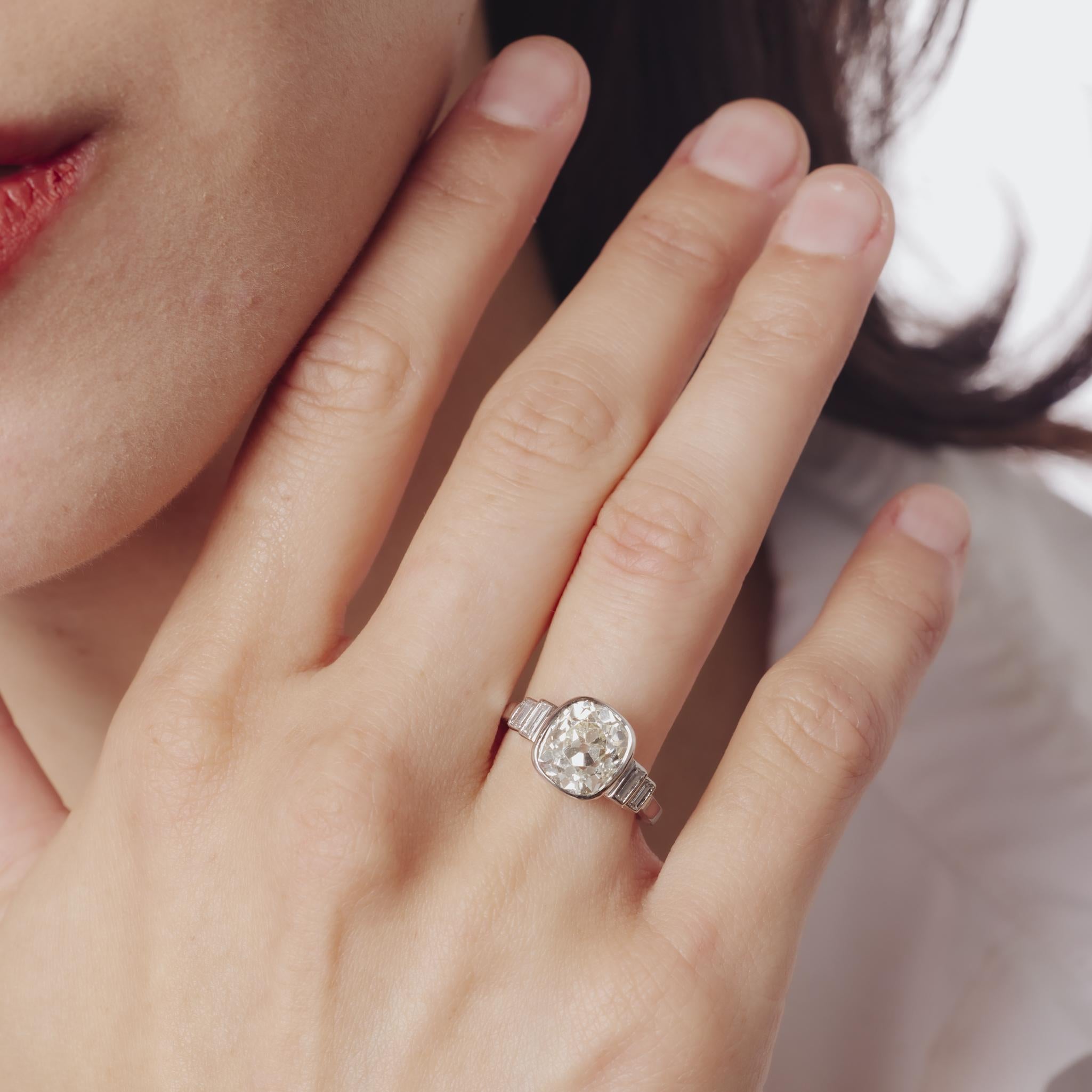 Questo raffinato anello Art Déco degli anni '30 è incentrato su un diamante taglio old mine da 3,29 carati certificato GIA, incorniciato da eleganti diamanti baguette e incastonato in un luminoso platino: un design senza tempo che incarna la