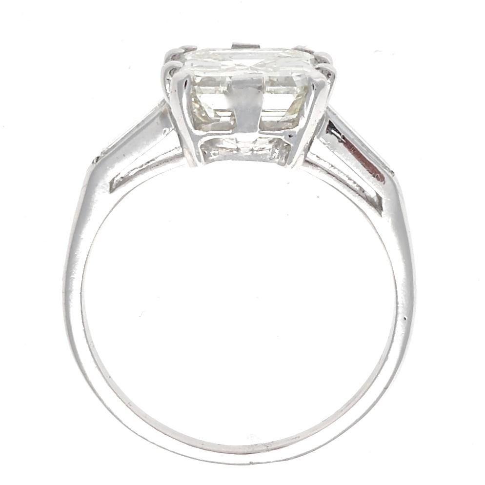 Art Deco emerald cut diamonds are regal in stature, great to look at and perfect for a night out on the town or shopping in the afternoon. GIA certified, 3.44 carats, K color,  VVS2 clarity. Accented with side baguette cut diamonds. The ring is