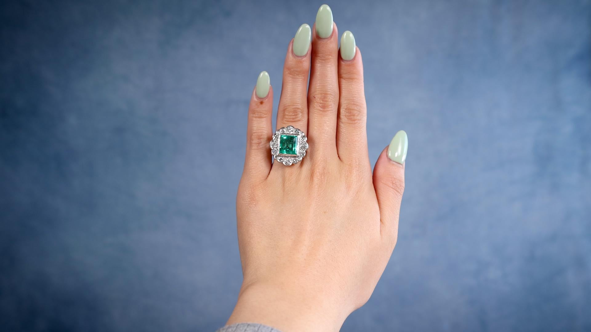 One Art Deco GIA 4.00 Carat Colombian Emerald Diamond Platinum Cluster Ring. Featuring one GIA rectangular step cut emerald weighing approximately 4.00 carats, accompanied by GIA #1236218394 stating the emerald is of Colombian origin. Accented by 16