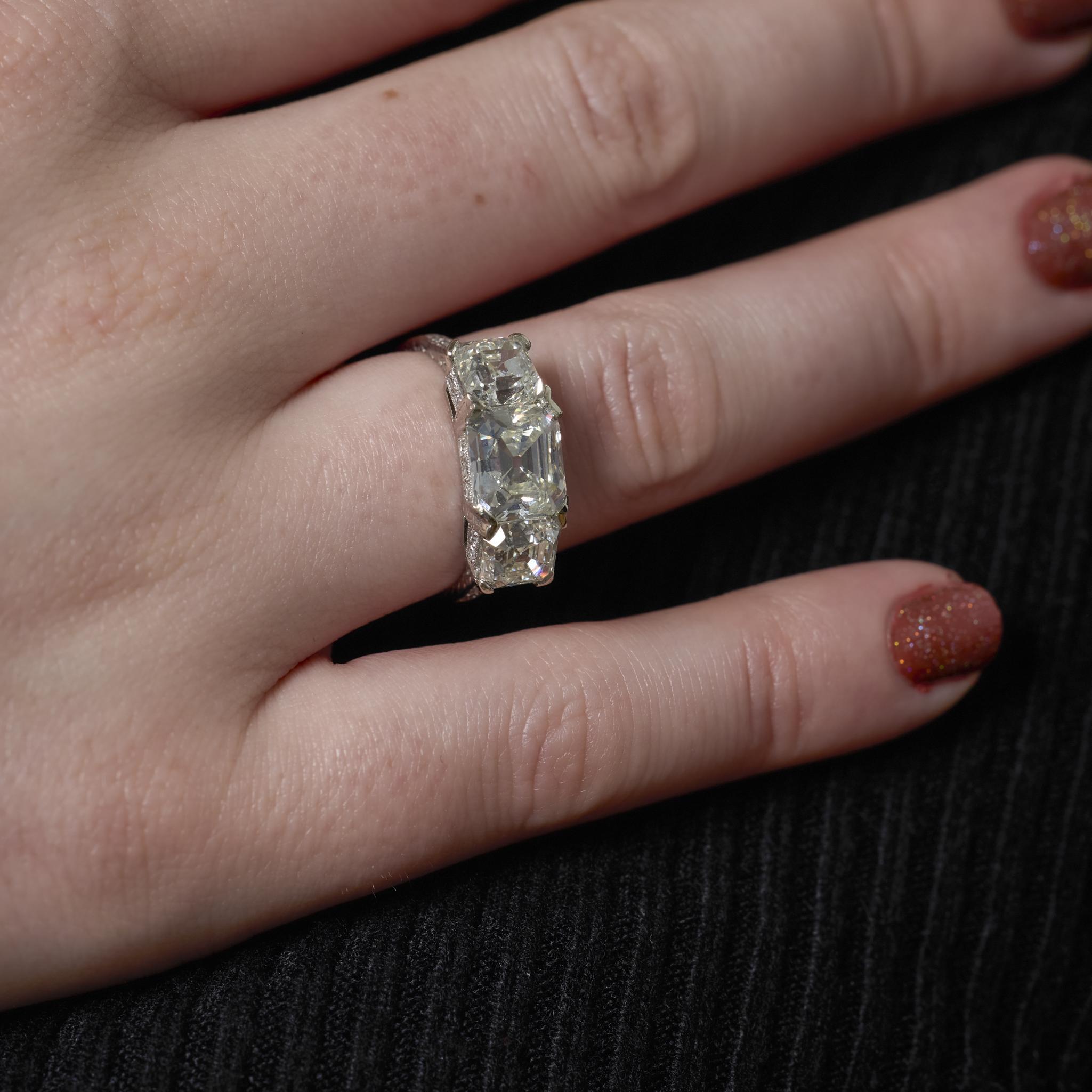 Questo anello in platino Art Deco degli anni '30 mette in mostra un trio di diamanti taglio Asscher, guidati da una pietra centrale di 2,63 carati certificata GIA. Affiancato da pietre laterali di 1,41 e 1,25 carati, il design incarna la geometria