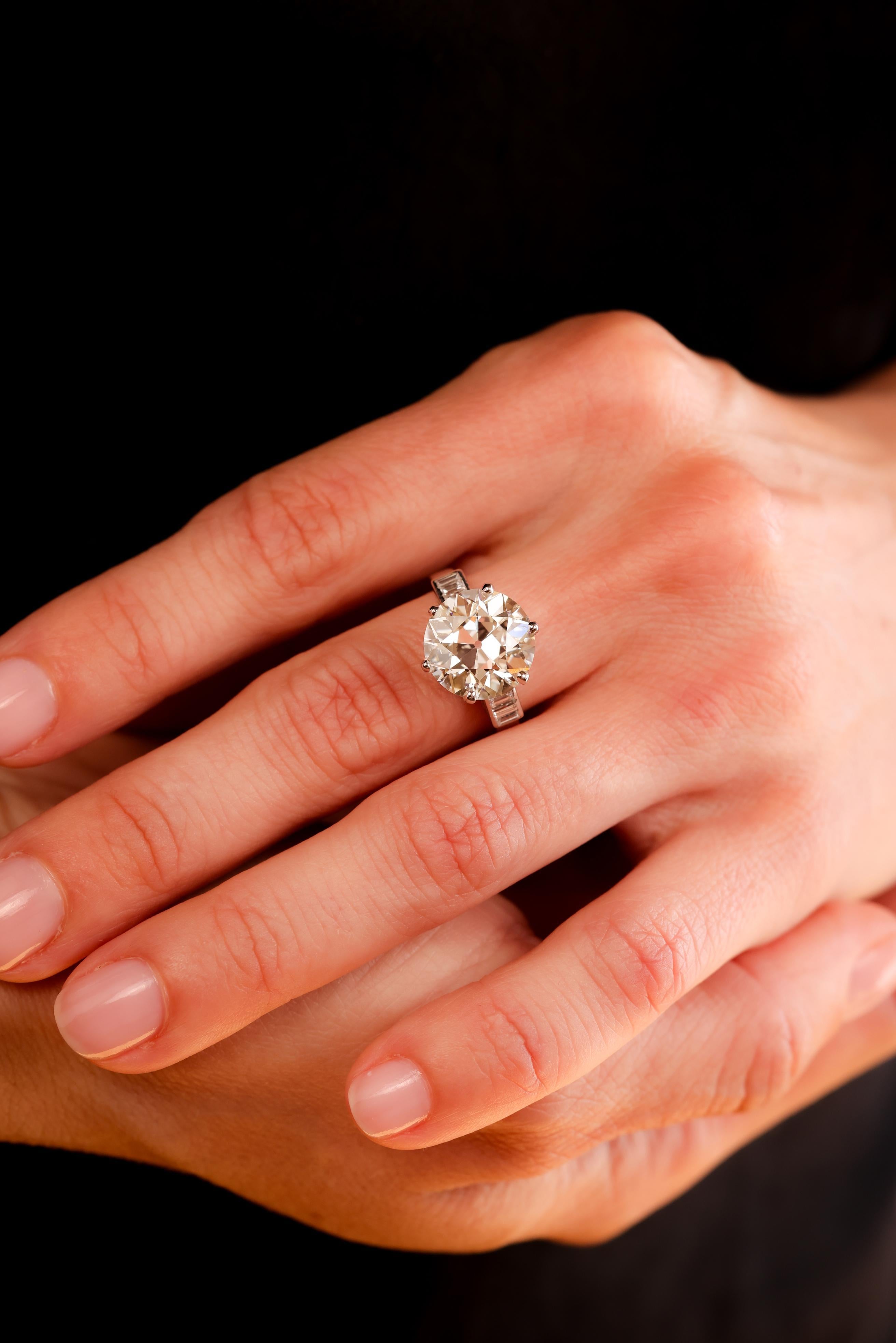 Mittelstein: Diamant
Zertifikat: GIA #6217493804
Schnitt:  Alteuropäisch
Gewicht: 6,69
Farbe: K
Klarheit: VVS1
Akzentuierungsstein: 6 Diamanten
Schnitt: Baguette
Gewicht: 0,3 Karat
Farbe: H
Klarheit: SI1
Metall: Platin
Epoche: Art Deco
Circa: 1930er