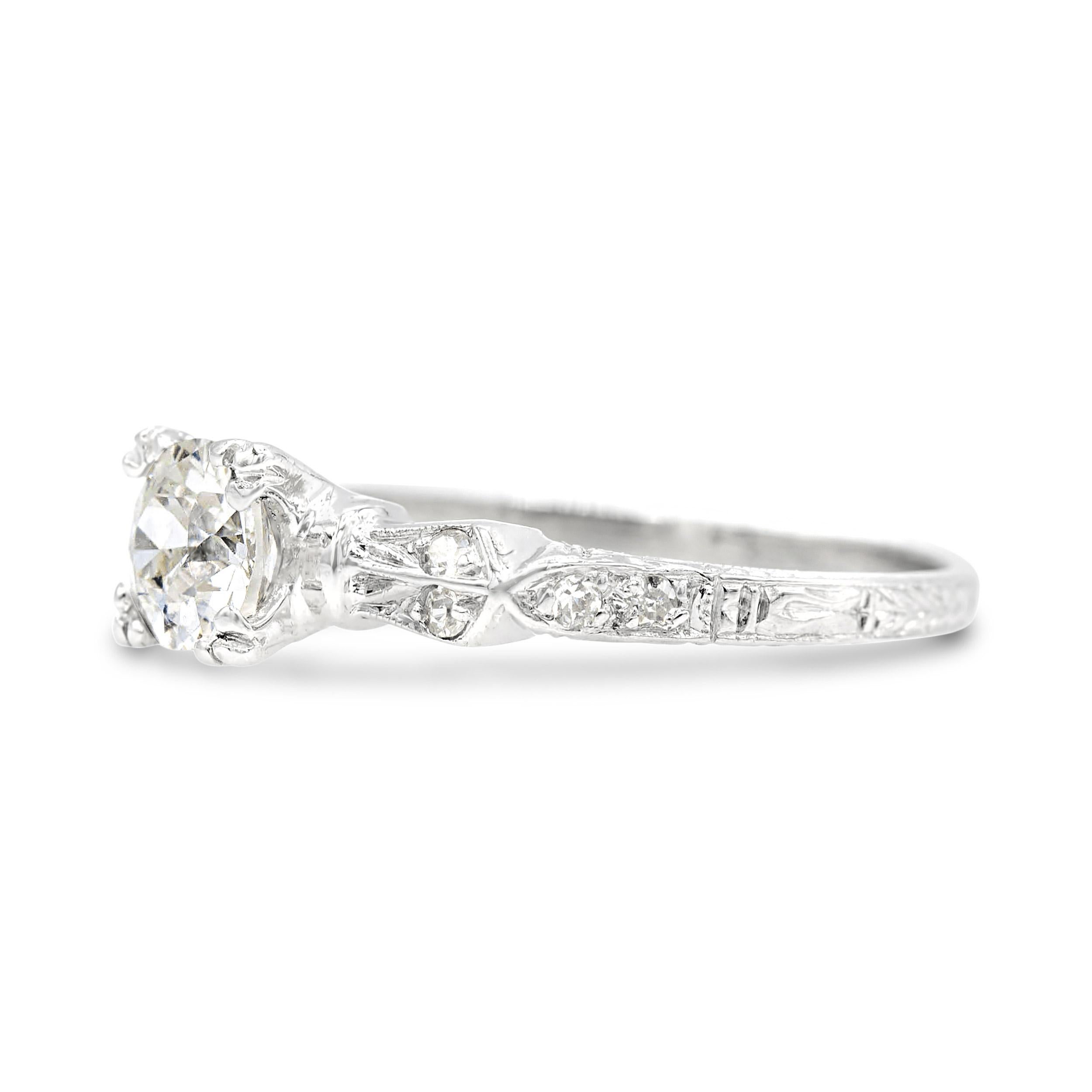 The revel is in the details of this distinctly Art Deco diamond engagement ring. At the center of the platinum crafted ring, a chunky half-carat old European diamond with a small table faces bright and white, appearing larger than its graded size.