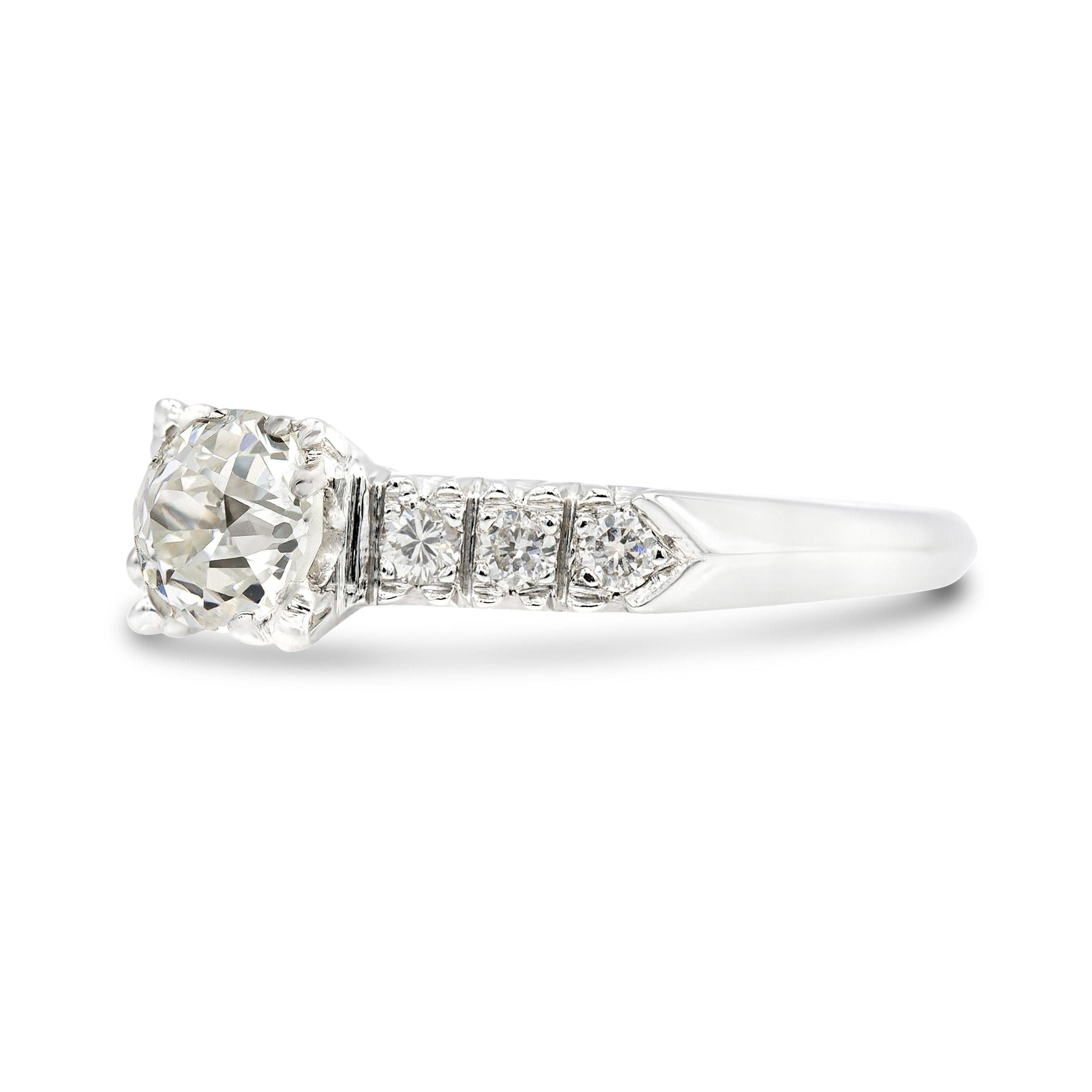 This is a classic of an Art Deco ring as it gets. Graded J VS2 by GIA, the old European center features a small table and has true deco-style faceting. On each side of the fishtail prong set stone, you can find three prong-set transitional round cut