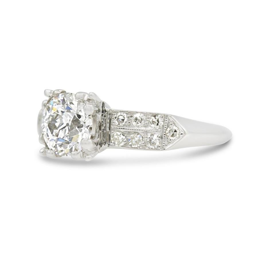 The arrowed and diamond-studded shoulders of this Art Deco engagement ring are striking. Crafted in platinum with hand-engraved milgrain details and a knife's edge shank this ring holds a beautiful 0.94 carat old European at its center and is set
