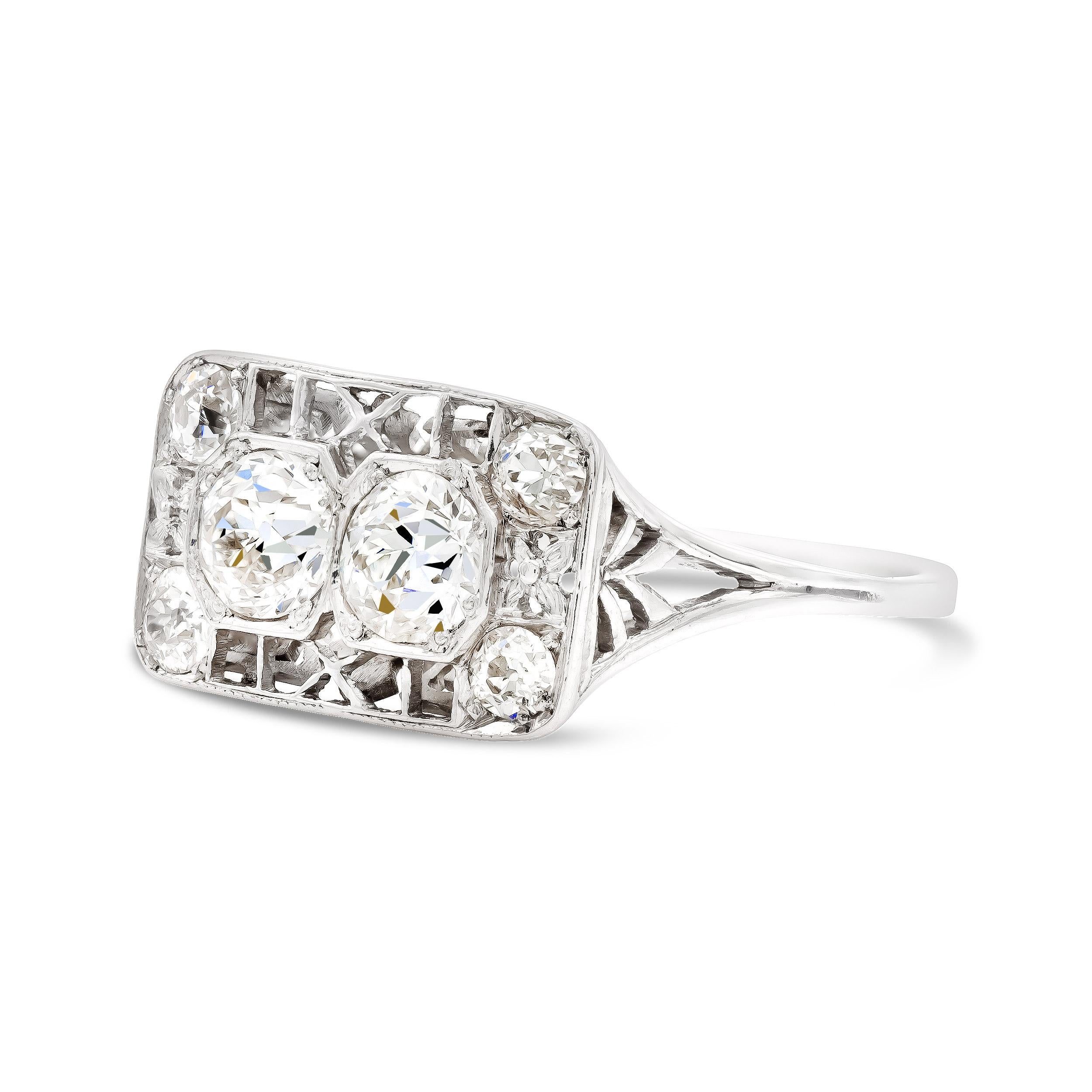 A twinkling twin set of old Euros sit nestled in this platinum filigree ring. At 1-carat total, they sparkle bright in an illusion octagonal setting. Its deco-era angular detailing throughout the face, gallery and band are charming beyond words. We