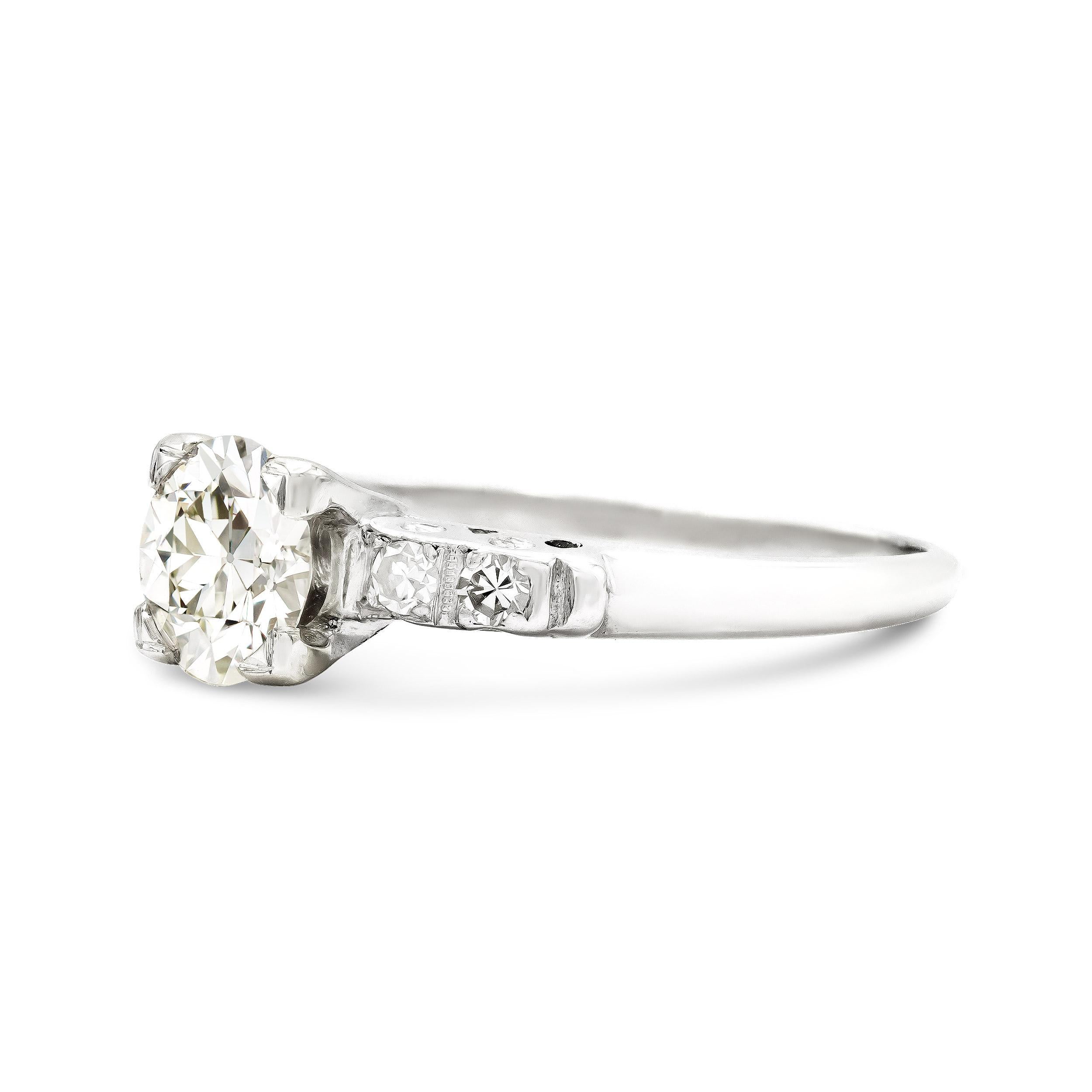 Here's a charming Art Deco era platinum engagement ring, sure to win any girl's heart. A super bright old European cut diamond is the center of attention, gleaming from a square basket. We love the round accent diamonds set in platinum, a classic