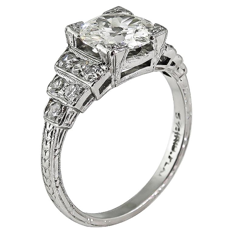 Cette superbe bague en platine de l'époque Art Déco est centrée sur un étincelant diamant taille ancienne certifié par le GIA qui pèse 1,20ct. de couleur J et de pureté VVS2. La pierre centrale est rehaussée d'éblouissants diamants ronds pesant