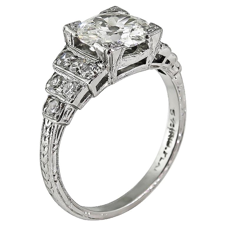 This stunning platinum ring from the Art Deco era, is centered with a sparkling GIA certified old mine cut diamond that weighs 1.20ct. graded J color with VVS2 clarity. Accentuating the center stone are dazzling round cut diamonds that weigh