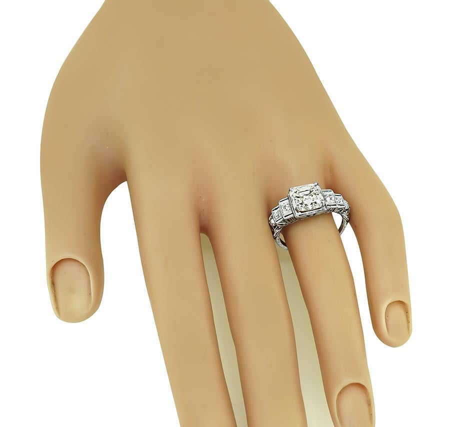 This is a stunning platinum engagement ring from the Art Deco era. The ring is centered with a sparkling GIA certified emerald cut diamond that weighs 3.01ct. The color of the diamond is K with VS2 clarity. The center diamond is accentuated by