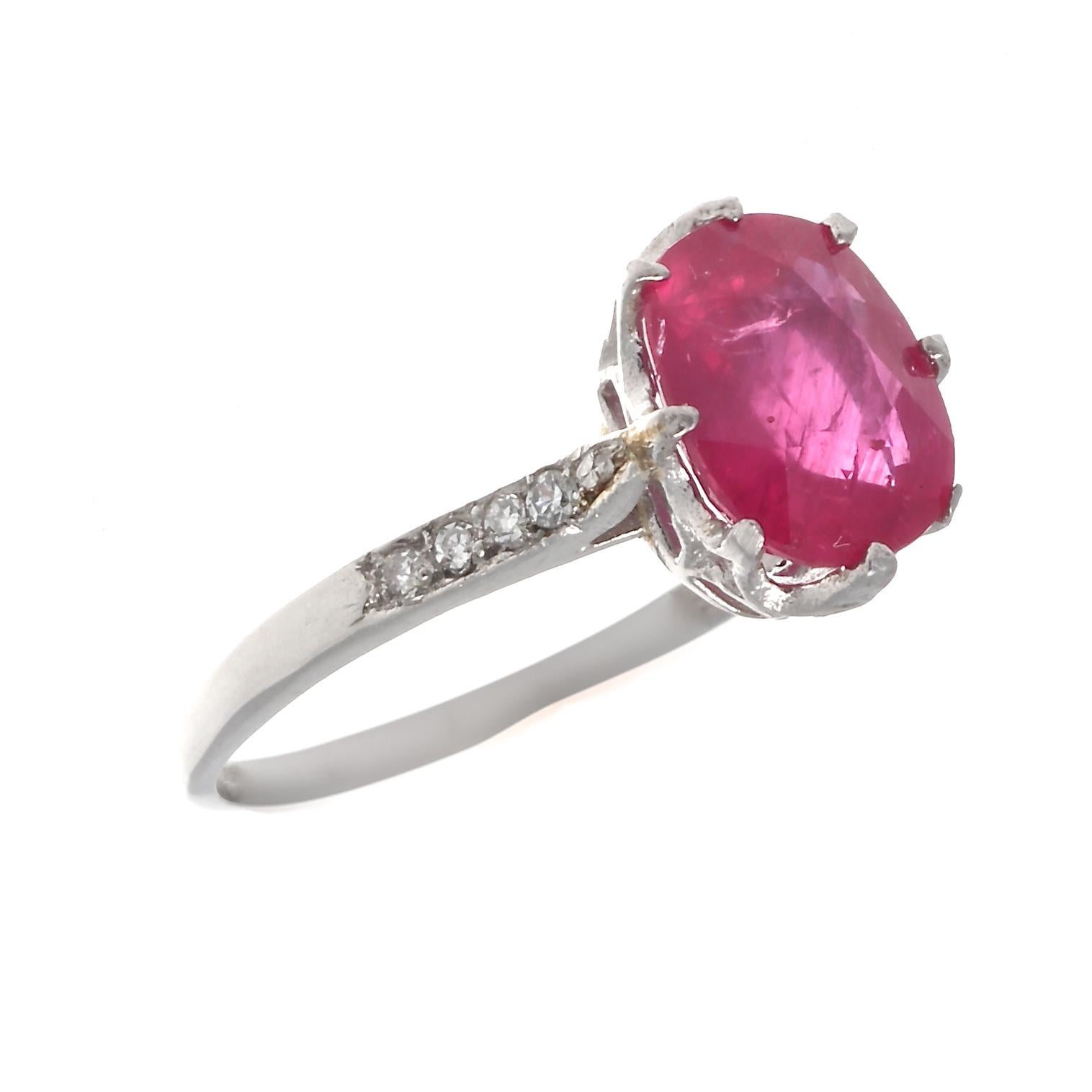 A symbol of commitment combined with the color of love. Featuring an approximately 1.60 carat glowing red oval cut ruby that is GIA certified. Classically accented by shoulders of numerous near colorless diamonds. Hand crafted in platinum. Ring size