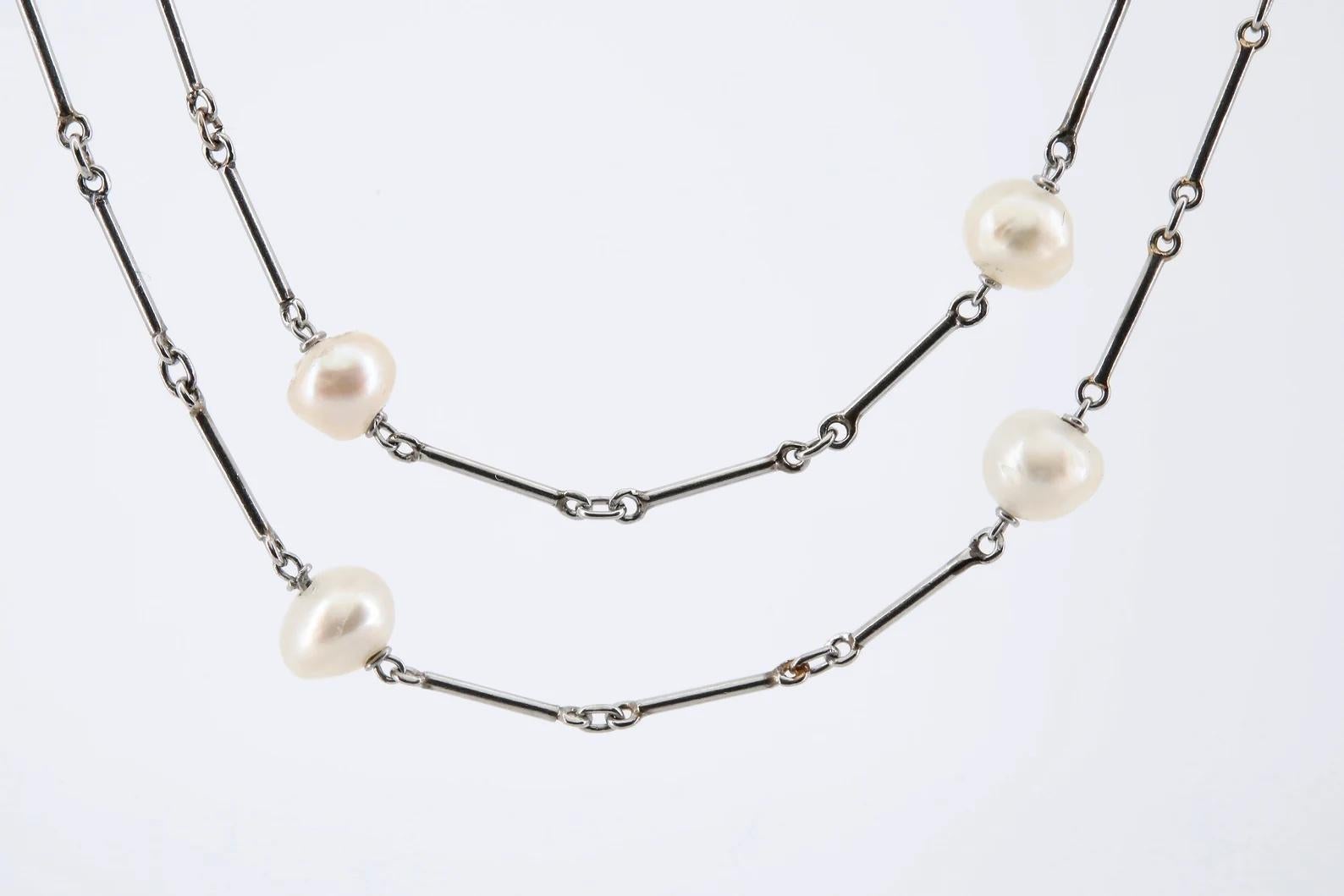 An original Art Deco period natural saltwater pearl necklace on platinum chain.

Featuring 20 natural white saltwater pearls with lustrous bright nacres, and measuring an average 5.50 millimeters in diameter.

The pearls stationed on a hand crafted